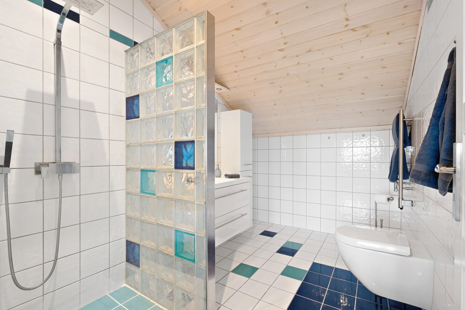 Romslig bad i 2. etasje fra 2008. Badet har dusj på gulv med dør i herdet glass, skillevegg i glassbyggerstein. Galleribilde