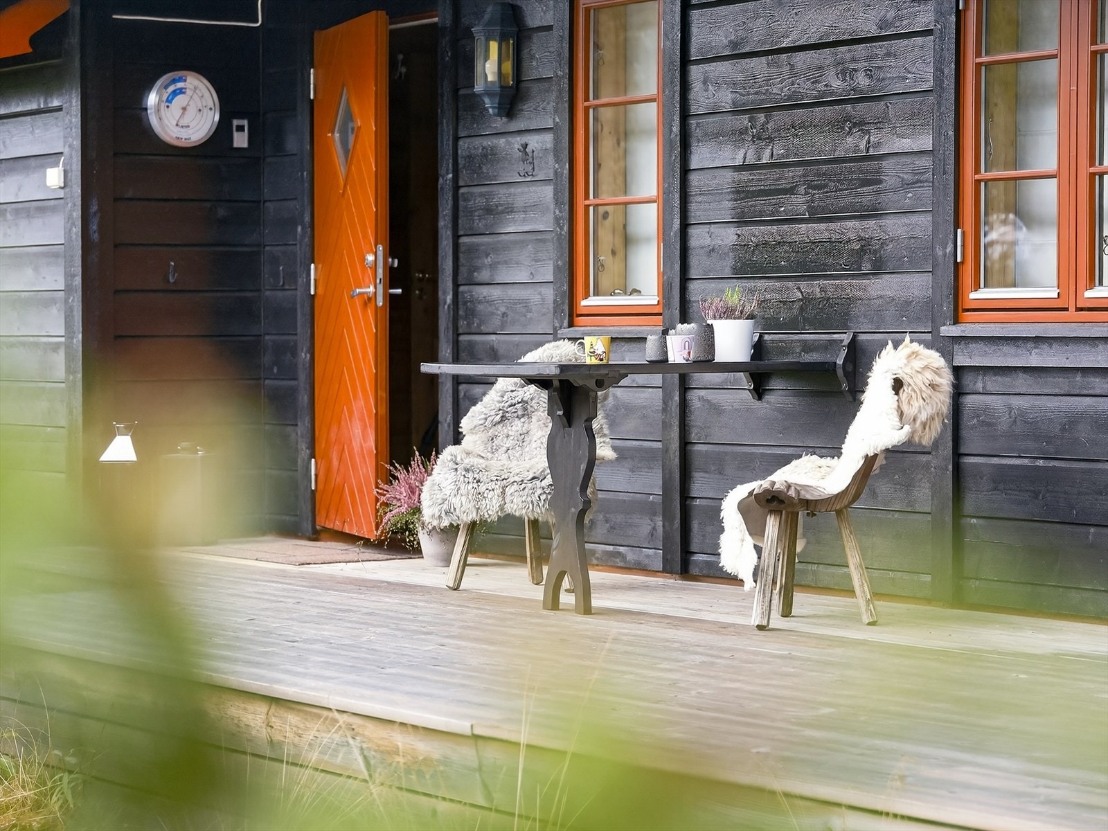 Hytta har en fin terrasse ved inngangspartiet med plass for en liten sittegruppe, blomster og lykter. Galleribilde