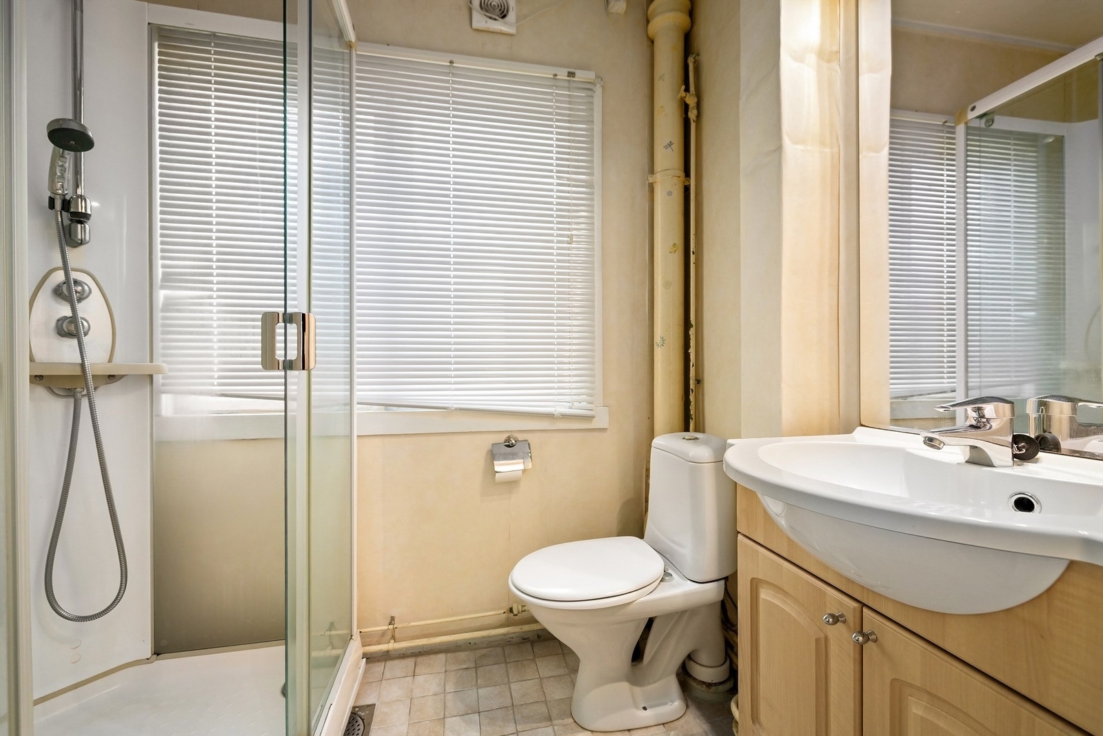 Innredet med dusjkabinett, vegghengt servant og gulvstående toalett Galleribilde