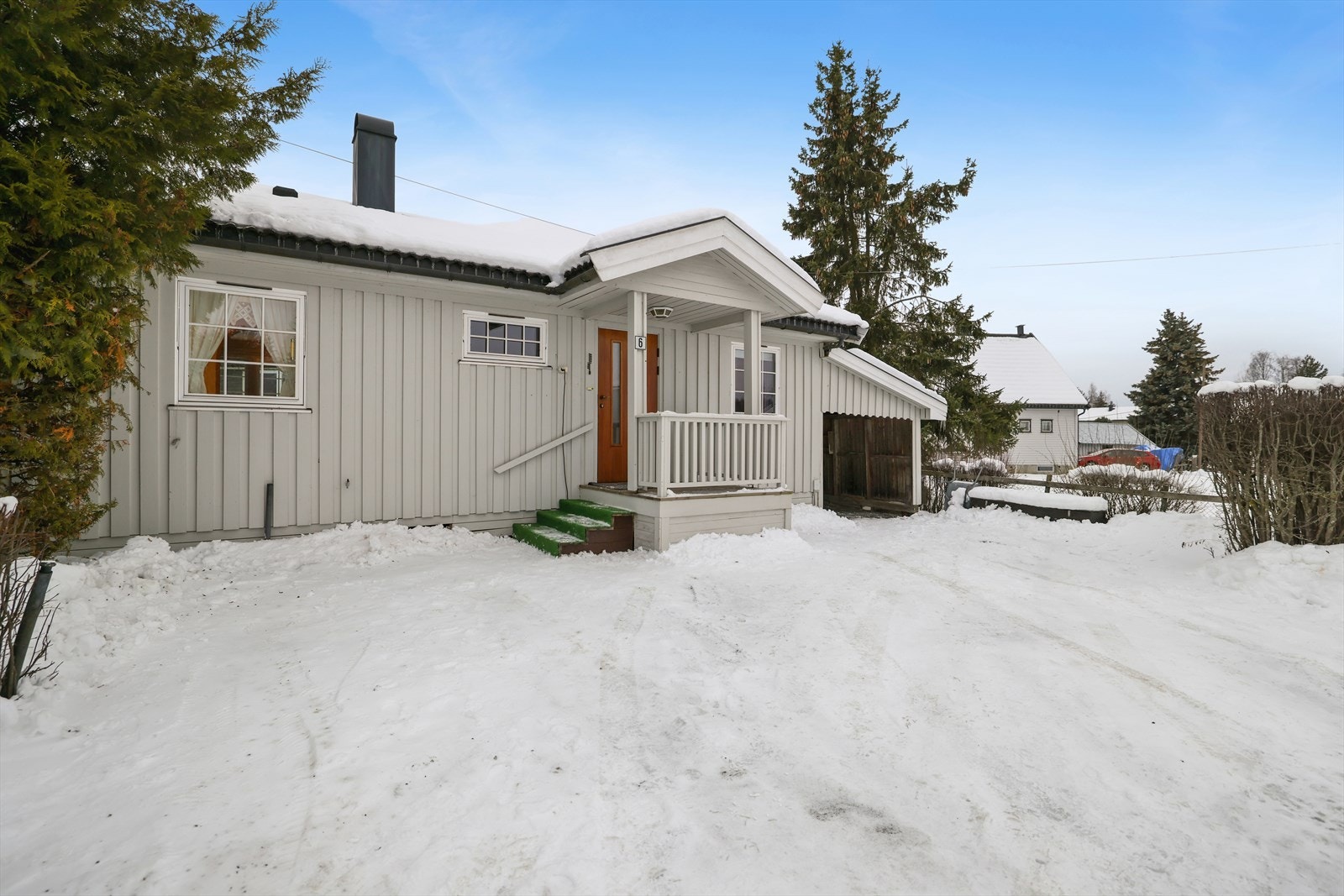 Overbygget inngangsparti med en platting på 5 m². Det er parkeringsplass i tilbygget carport. Denne er ikke godkjent, se pkt."ferdigattest" i salgsoppgaven for mer informasjon. Galleribilde