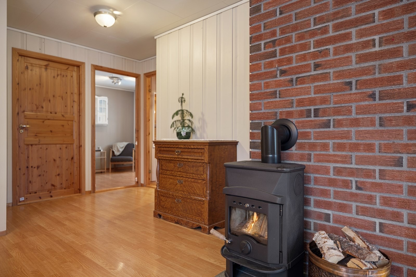 Peisovnen, plassert mot en teglforblendet pipe, gir både varme og en hyggelig atmosfære. Galleribilde