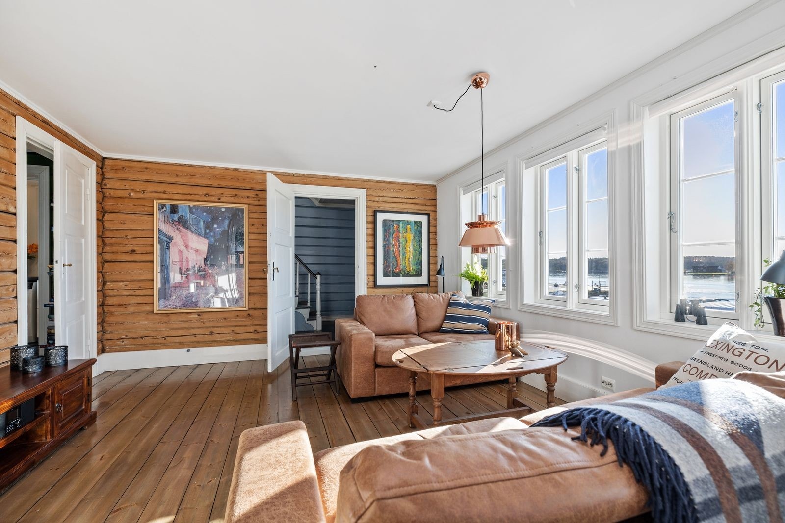 De fine tømmerveggene og det originale tregulvet i hovedstuen gir rommet særpreg samtidig som det understreker solid gammel byggeskikk. Galleribilde