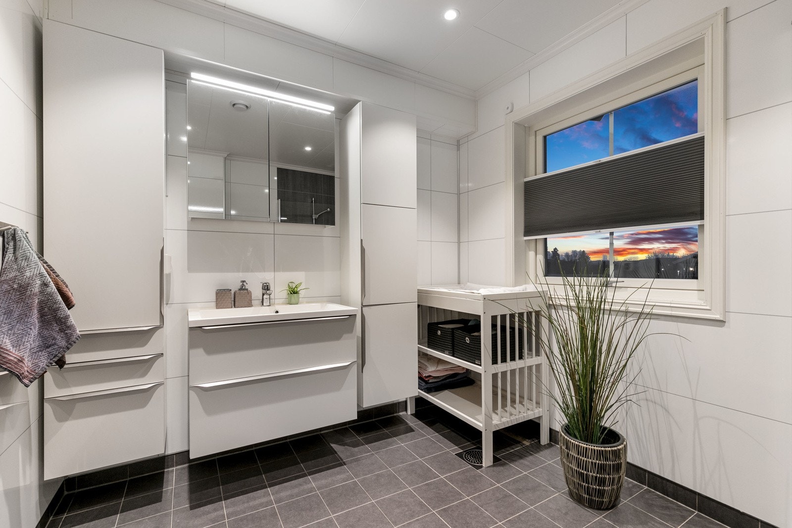 Delikat og smakfullt hovedbad fra 2018 med varmekabler i gulv. Himlingen er pent lyssatt med downlights. Flislagt gulv og baderomsplater på vegger. Galleribilde