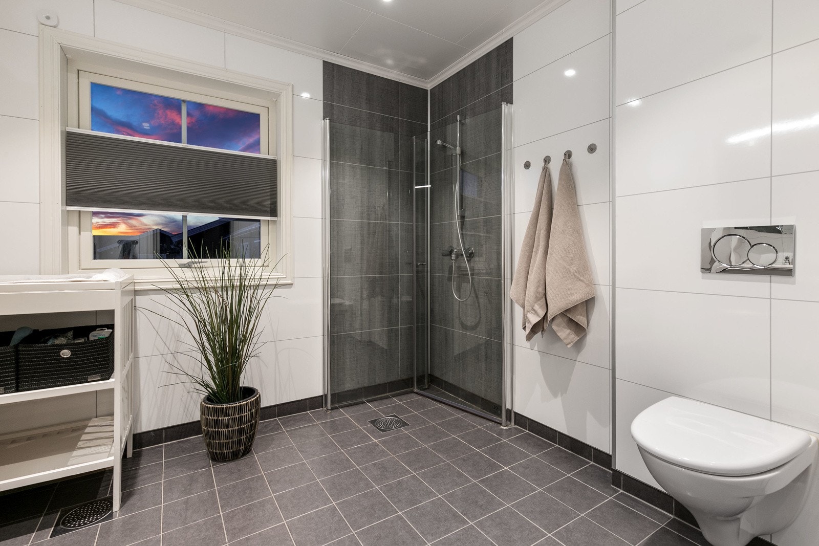 Videre har badet dusjhjørne med innfellbare dører og vegghengt toalett. Galleribilde