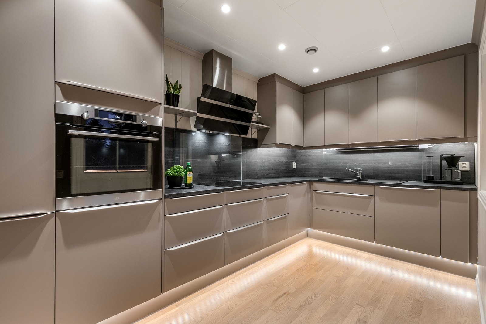 Lekker stemningsbelysning setter et pent preg. Kjøkkenet har moderne fronter, med lekre håndtak. Kjøkkenet har flotte integrerte hvitevarer som kjøl/frys, oppvaskmaskin, platetopp og stekeovn. Galleribilde