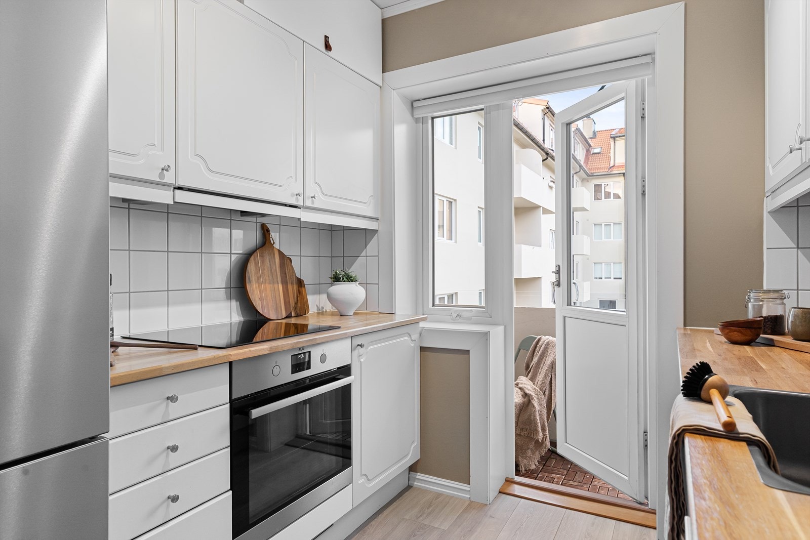 Integrerte hvitevarer som komfyr og platetopp er pent bygd inn i nytt skap fra Epoq(2024), og oppvaskmaskin med hvit front bidrar til et helhetlig og ryddig uttrykk. Galleribilde