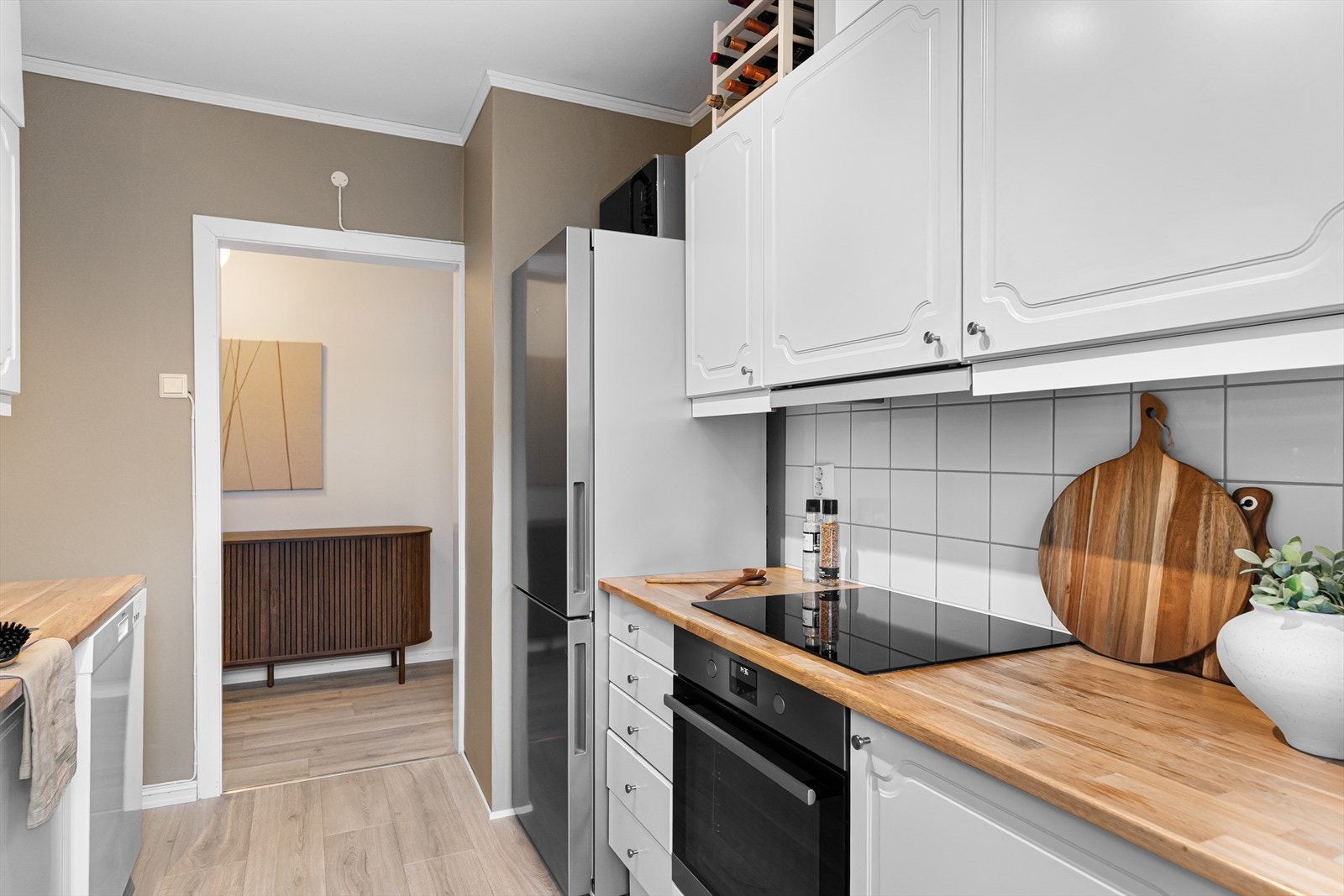 Kjøkkenet er innredet med Ikea-innredning med hvite, profilerte fronter som gir et tidløst uttrykk. Galleribilde