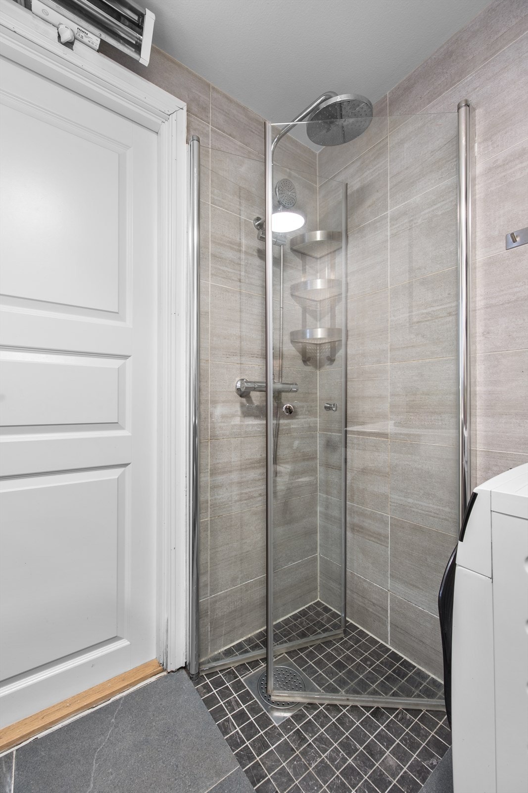 Praktiske innfellbare dusjdører og opplegg for vaskemaskin. Varmelampe over dør. Galleribilde