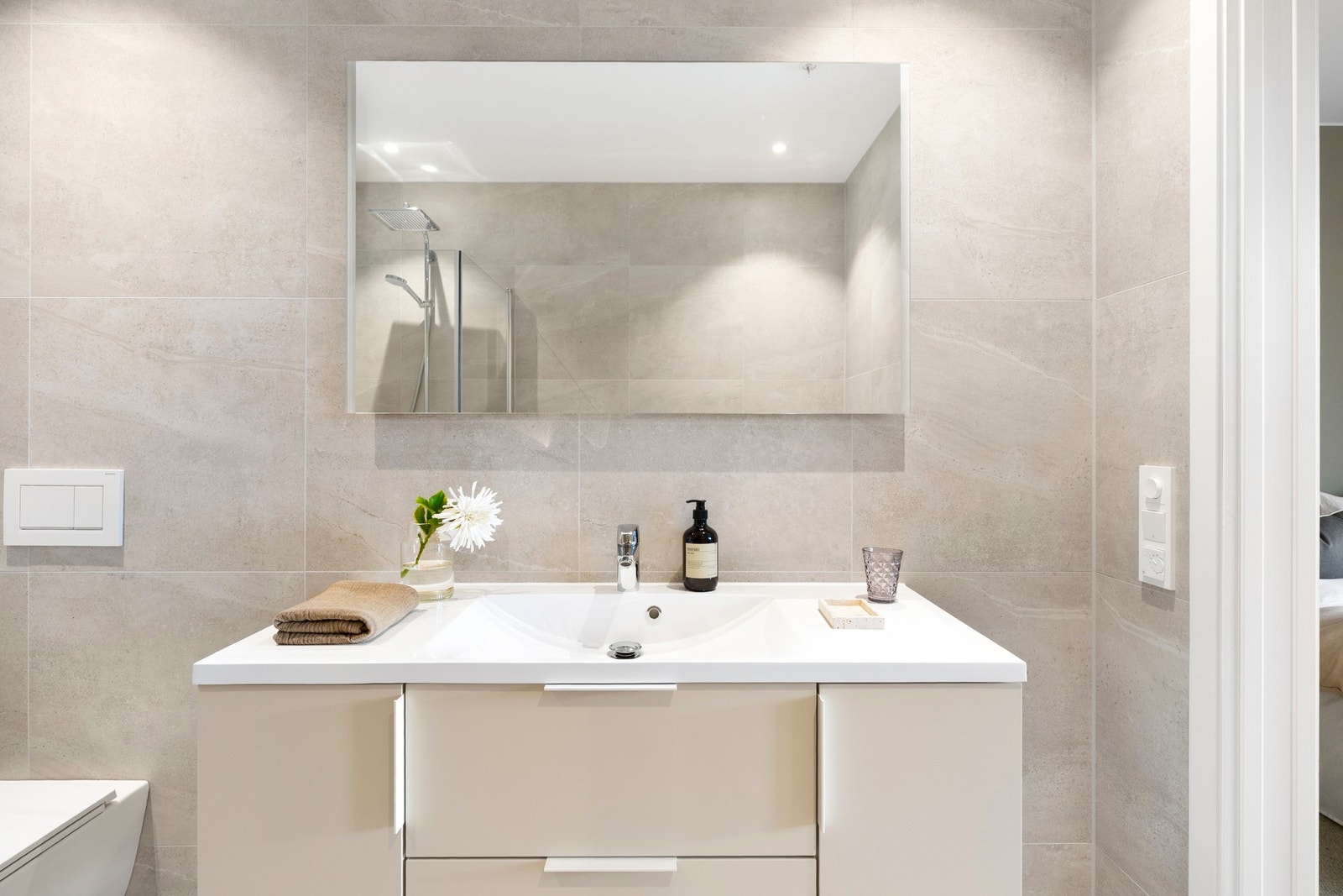 Badet har en moderne finish med store duse fliser, gulvvarme og kvalitetsinnredning fra Sigdal. Galleribilde