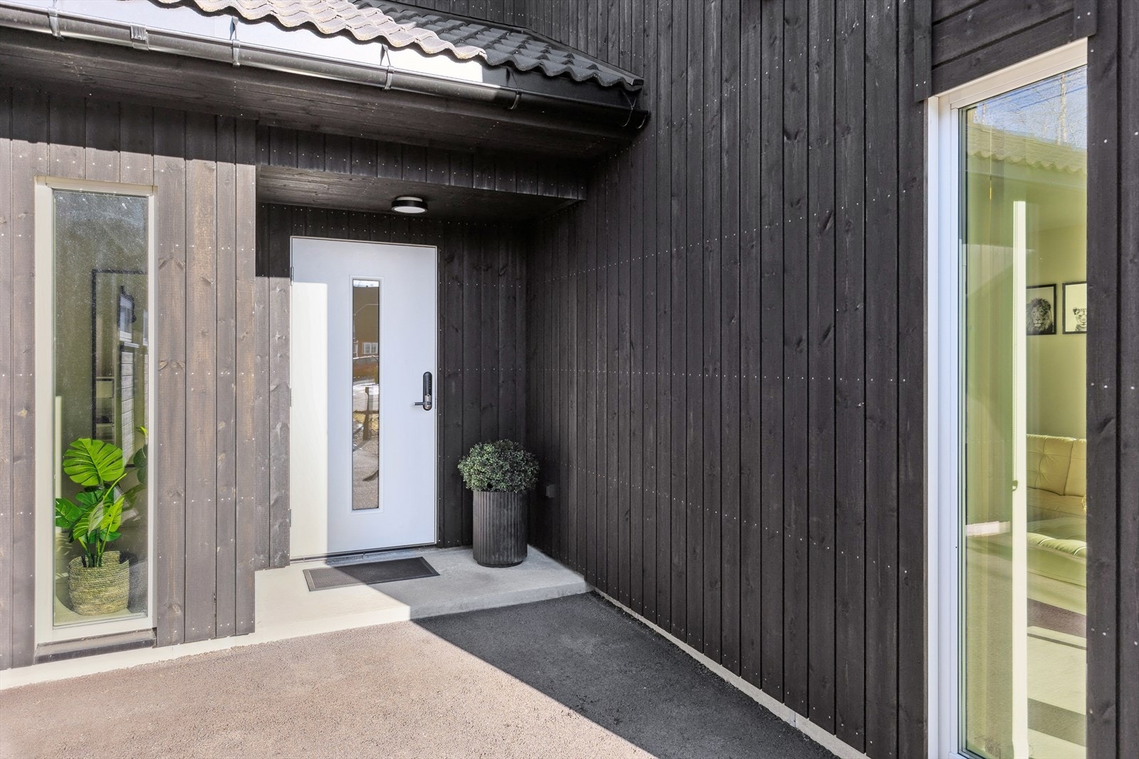 Overbygget inngangsparti fra asfaltert gårdsplass Galleribilde