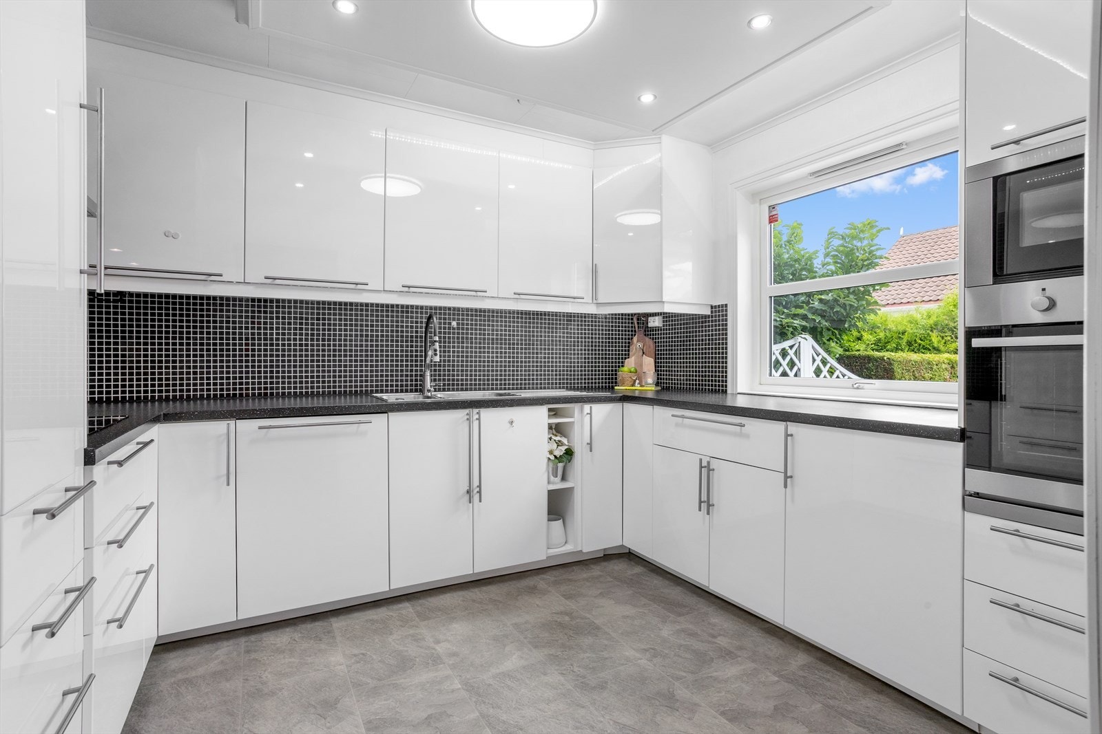 Kjøkkenet fremstår lyst og funksjonelt, med vinylbelegg på gulvet, malte slette flater på veggene og himlingsplater i taket. Galleribilde