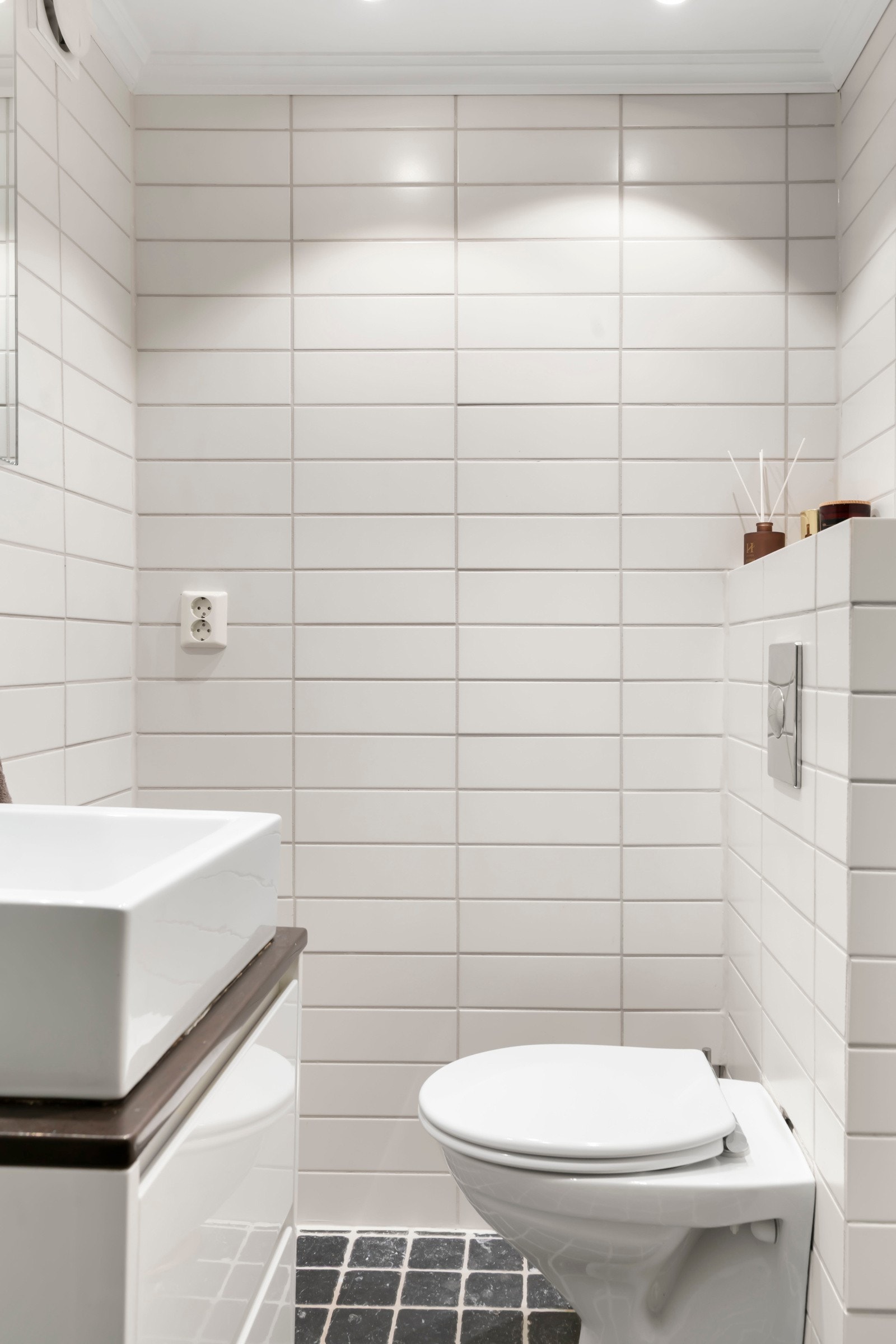 Flislagt baderom med behagelig varmekabler i gulv, dusjhjørne med glassdører og regnfallsdusj, veggmontert toalett. Galleribilde