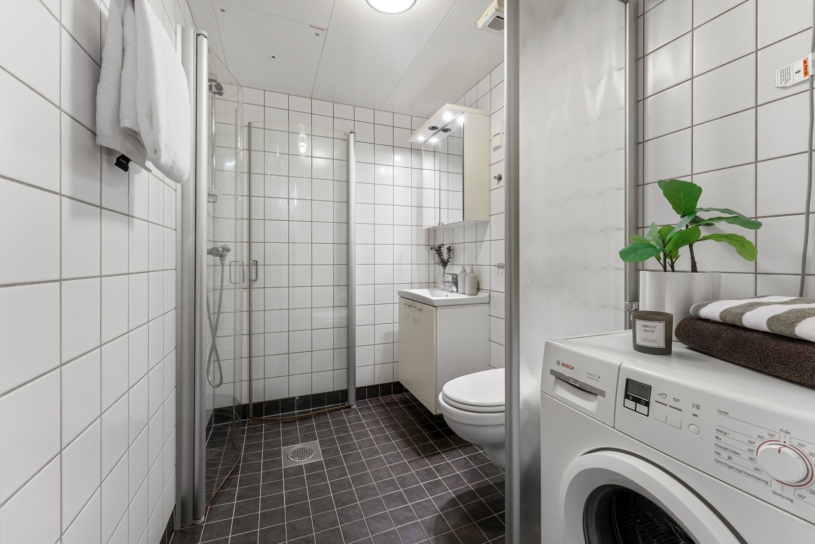 Baderom fra byggeår - Utstyrt med dusjhjørne, vegghengt klosett og opplegg for vaskesøyle. Galleribilde