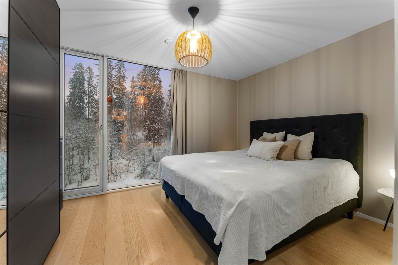 Hovedsoverommet er svært romslig, med stilig taklampe, beige vegger og mye naturlig lys. Galleribilde