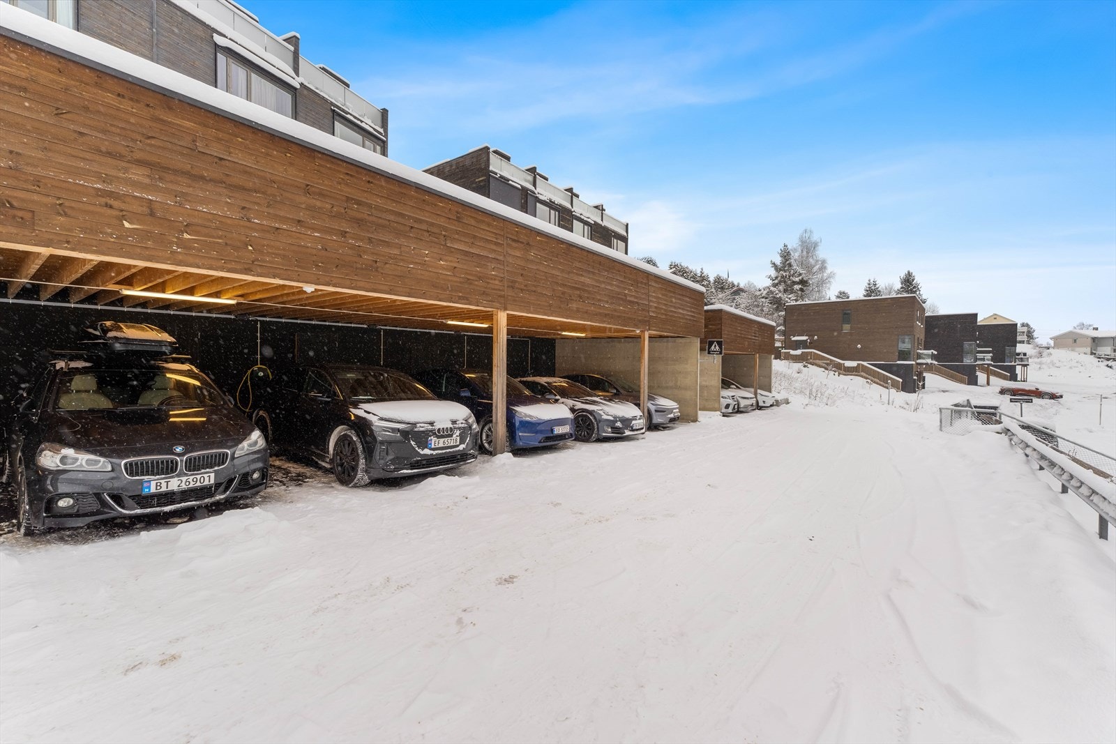 Rekkehuset disponerer en carport i felles rekke. I carporten har boligen en lader for elbil og en sportsbod for praktisk lagring utendørs. Galleribilde