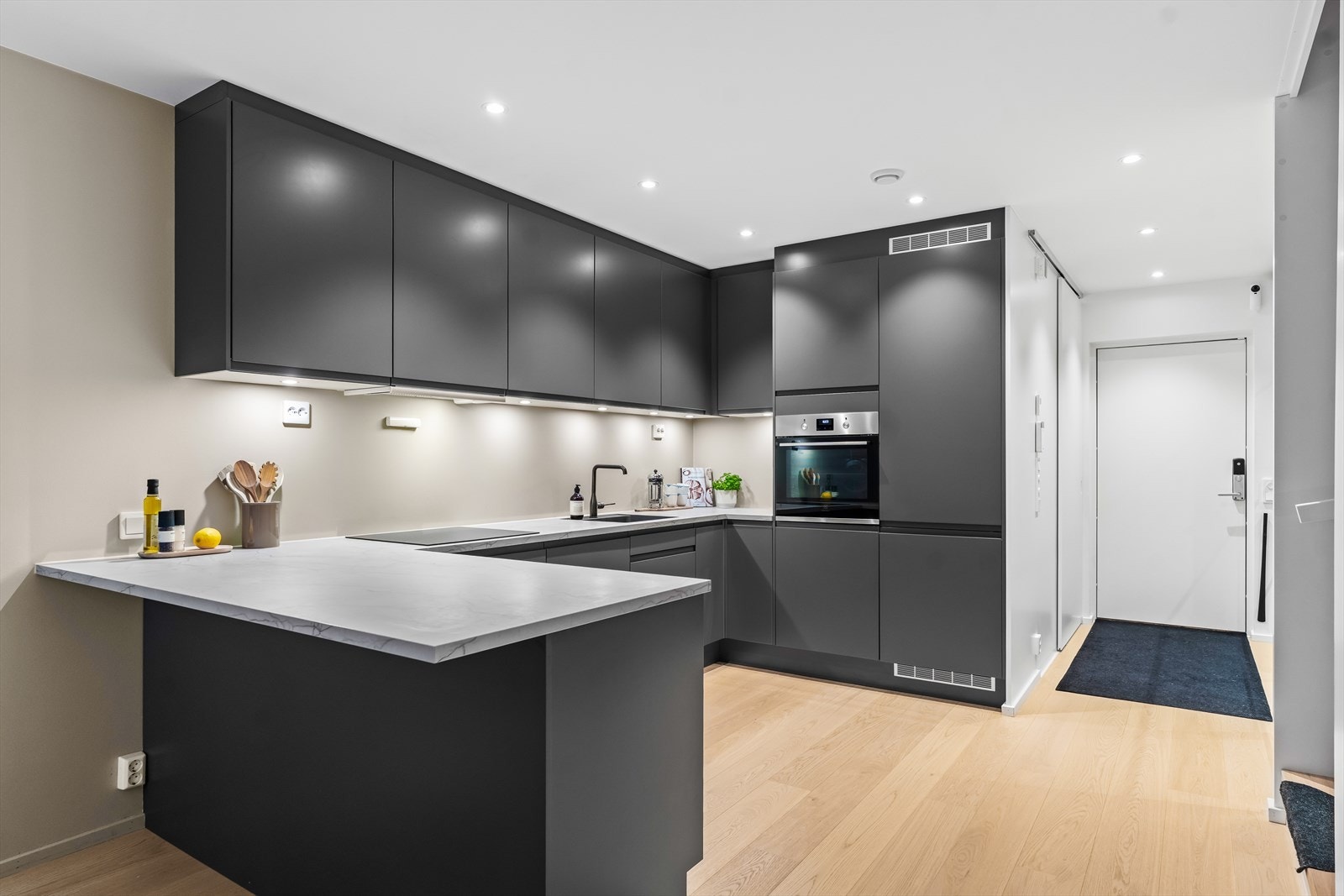 Alle hvitevarene er integrerte, bestående av platetopp, oppvaskmaskin, stekeovn i høyskap og en kombinert kjøl/frys. Galleribilde