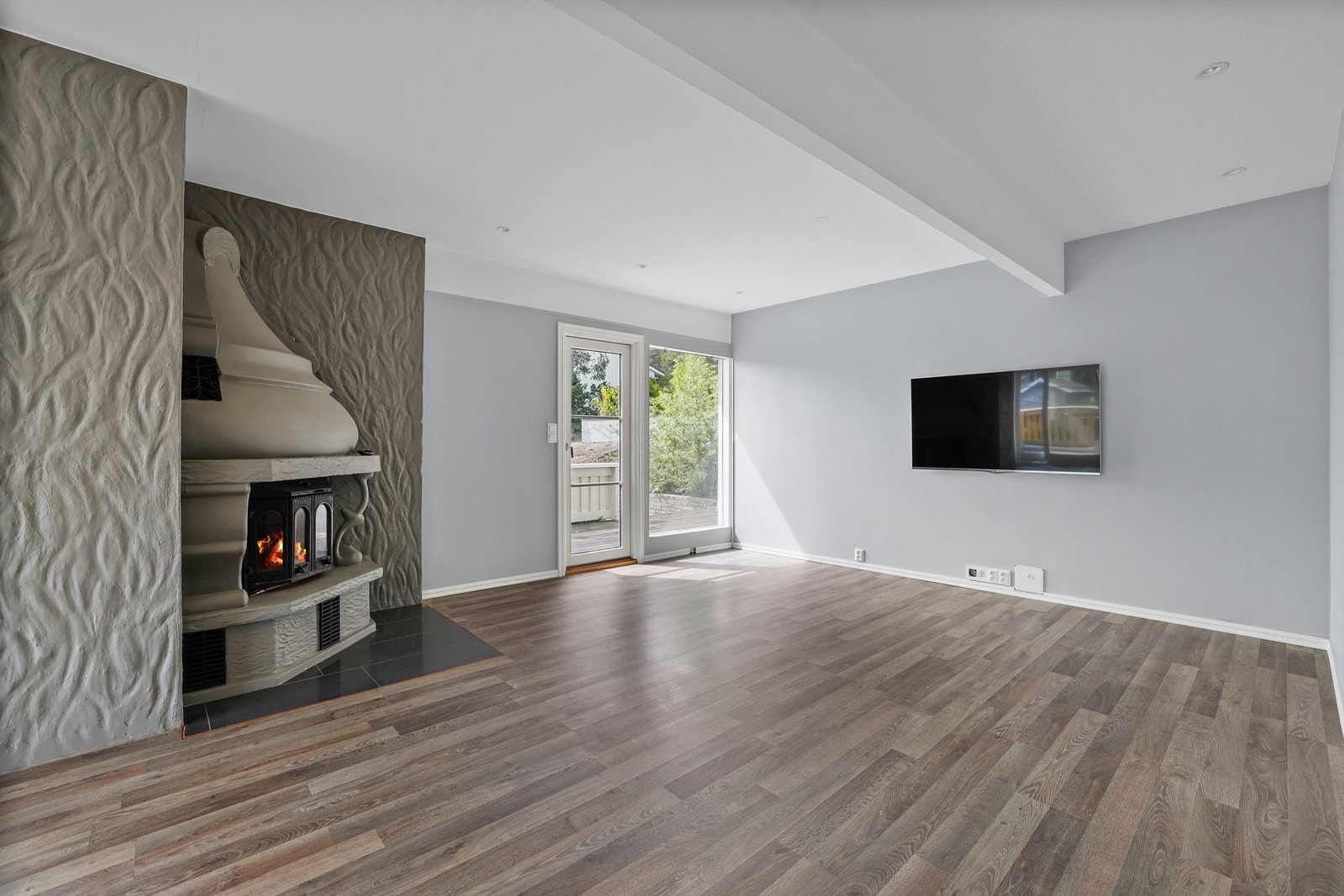 Stuens mest avskjermede del passer godt som TV-krok, her er det også mulighet for stemningsfremmende peishygge. Galleribilde