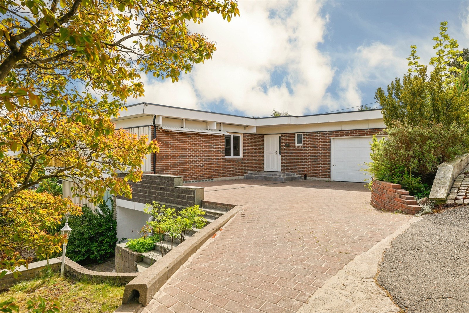 Tilbygget garasje er isolert, har leddport med motorisert åpner og innvendig adkomst via branndør mot boligens hoveddel. Galleribilde