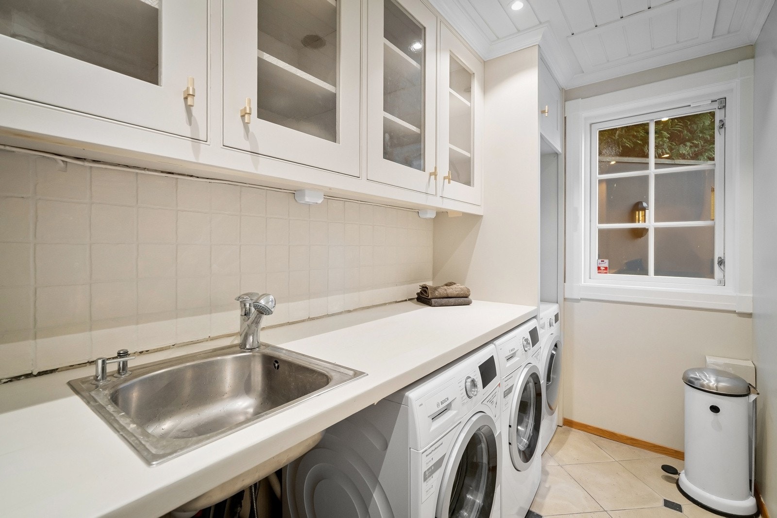 Praktisk vaskerom i nær tilknyttning til kjøkkenet. Opplegg for vaskemaskin og tørketrommel, samt godt med oppbevaringsplass. Galleribilde