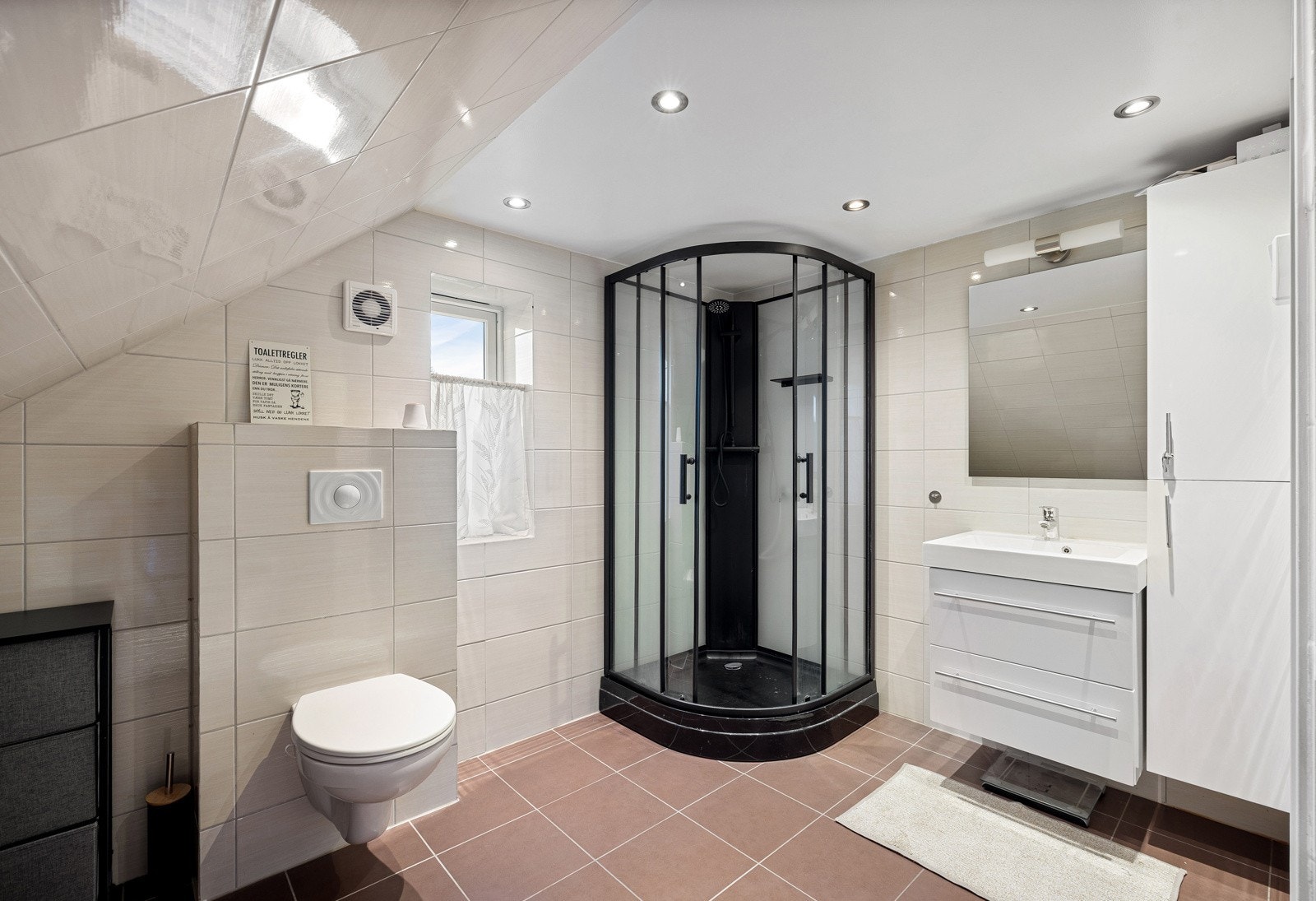 Oppe ligger et romslig, flislagt baderom med varme i gulvet og downlights i taket. Galleribilde