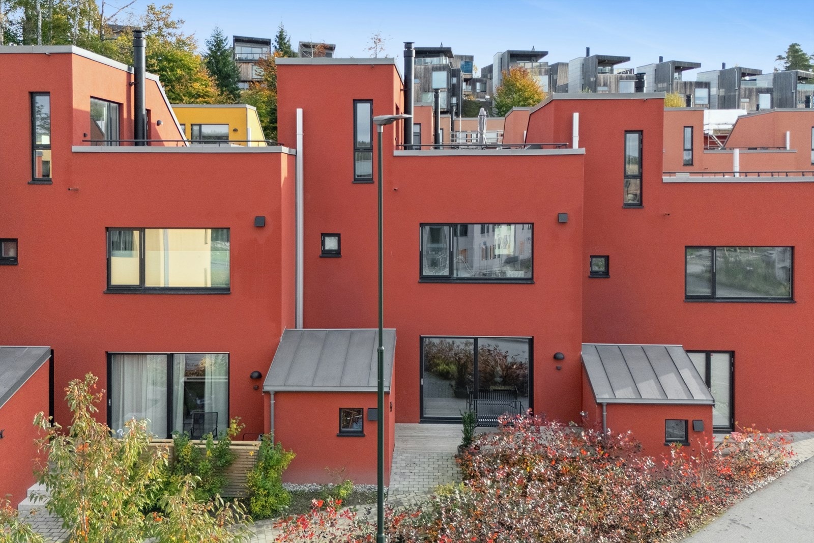 Innbydende inngangspartiet til boligen med belegningsstein, en fin markterrasse, samt en utvendig bod. Galleribilde