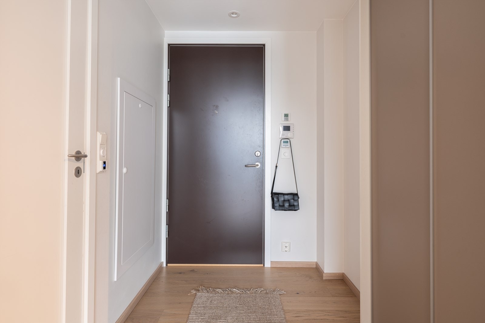 Romslig gang med skyvedørsgarderobe og porttelefon Galleribilde