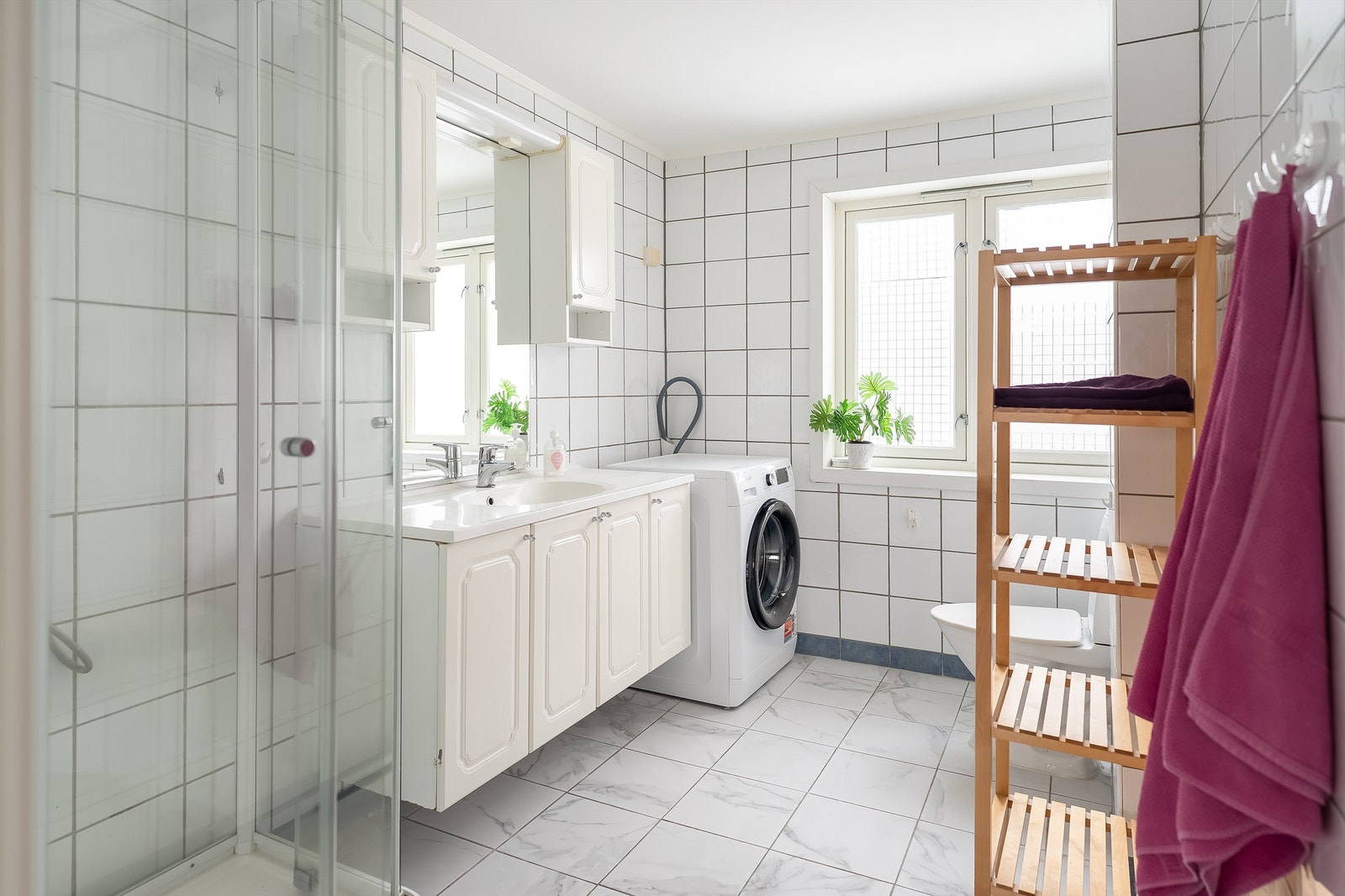 Romslig flislagt bad på i underkant av 6 kvm. God plass for vaskemaskin Galleribilde