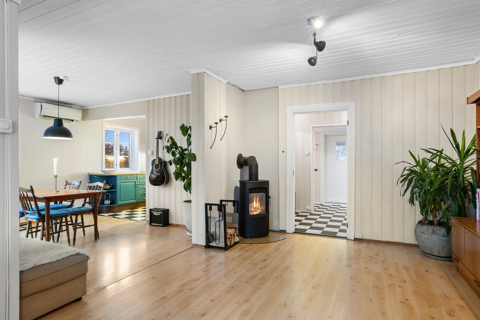 Stue med vedovn og varmepumpe. Store vindusposter gir gode innvendige lysforhold. Galleribilde