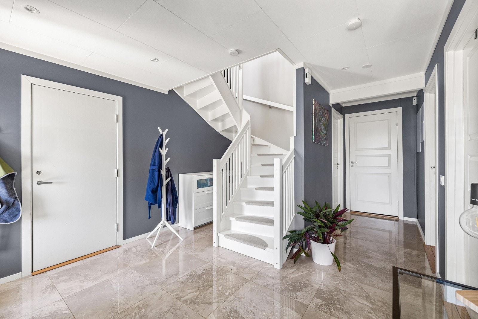 Stor og innbydende hall med flislagt gulv og god plass til oppbevaring. Galleribilde