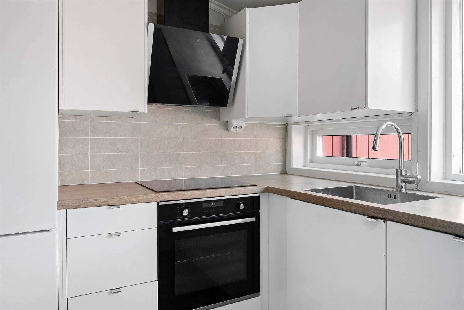 Kjøkkenet har delvis integrerte kvitevarer, slette frontart og laminert benkeplate Galleribilde