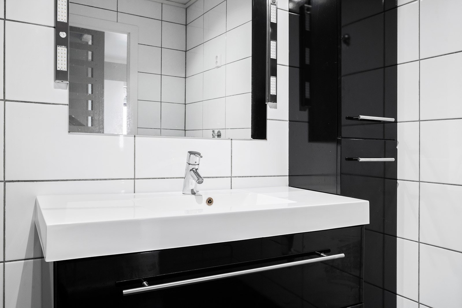 Fin innreiing med vegghengt klosett, dusjhjørne, høgskap og servant i underskap Galleribilde