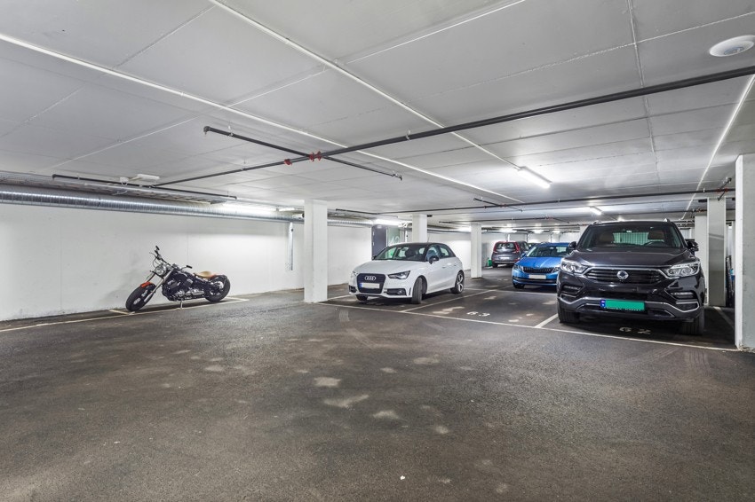 Leiligheten har en fast parkeringsplass i felles garasjekjeller (merket 63) som følger med salget. Galleribilde