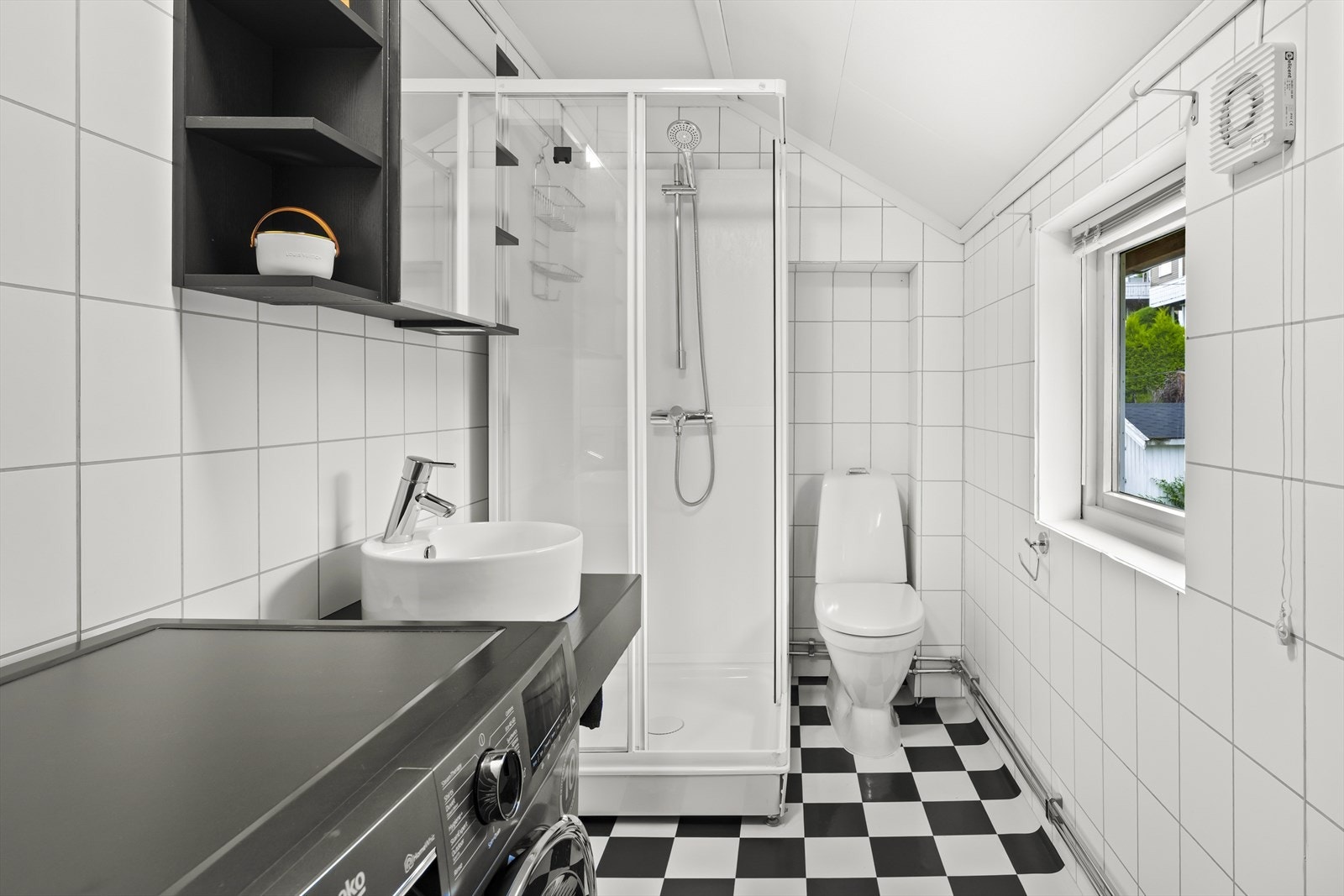 Badet er innredet med servant, speilskap, toalett, dusjkabinett og opplegg for vaskemaskin. Galleribilde