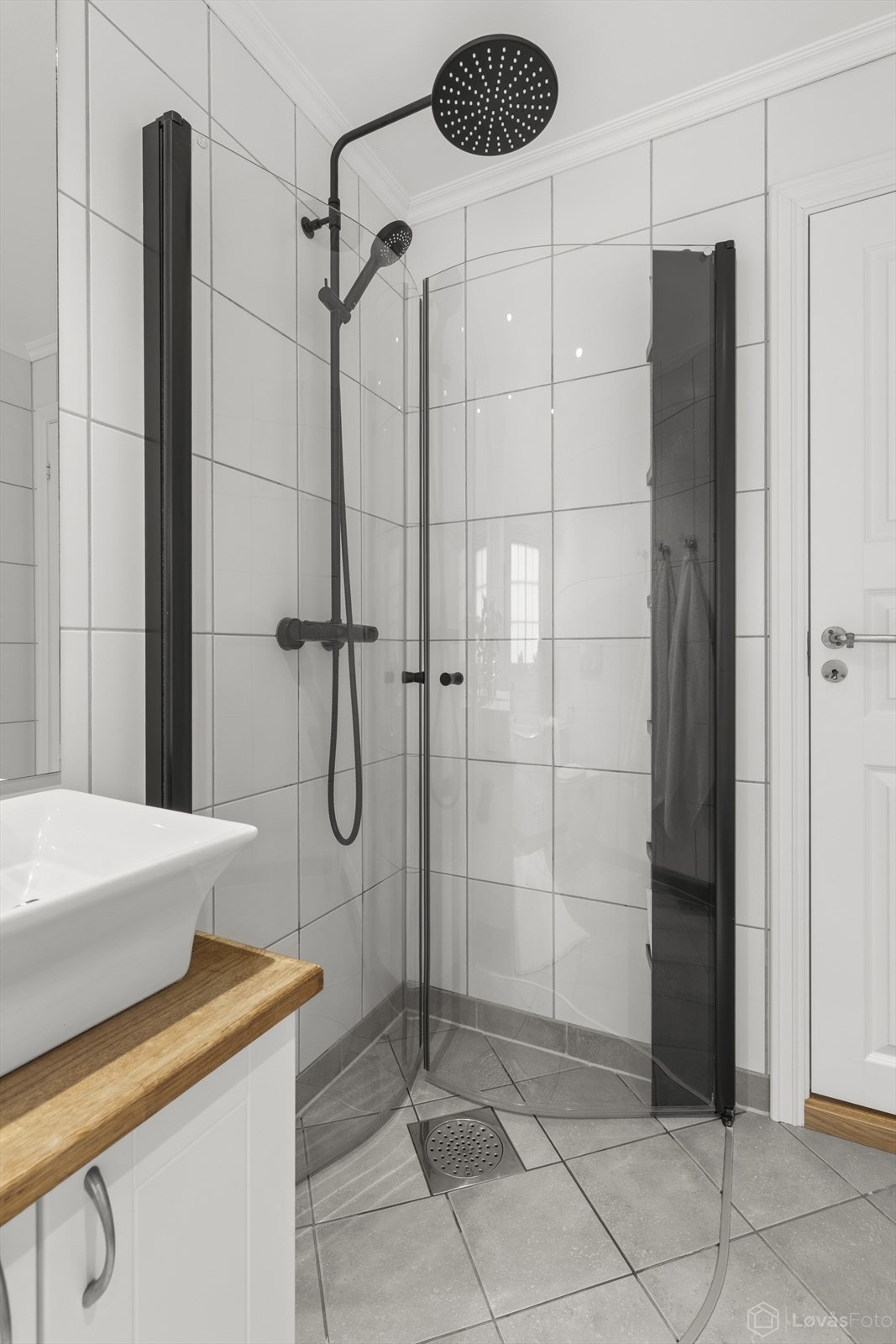 Dusjhjørne med nye innfellbare glassdører i 2025 og med nytt sort dusjarmatur i 2025 tilkoblet både hånddusj og regnfallsdusj Galleribilde