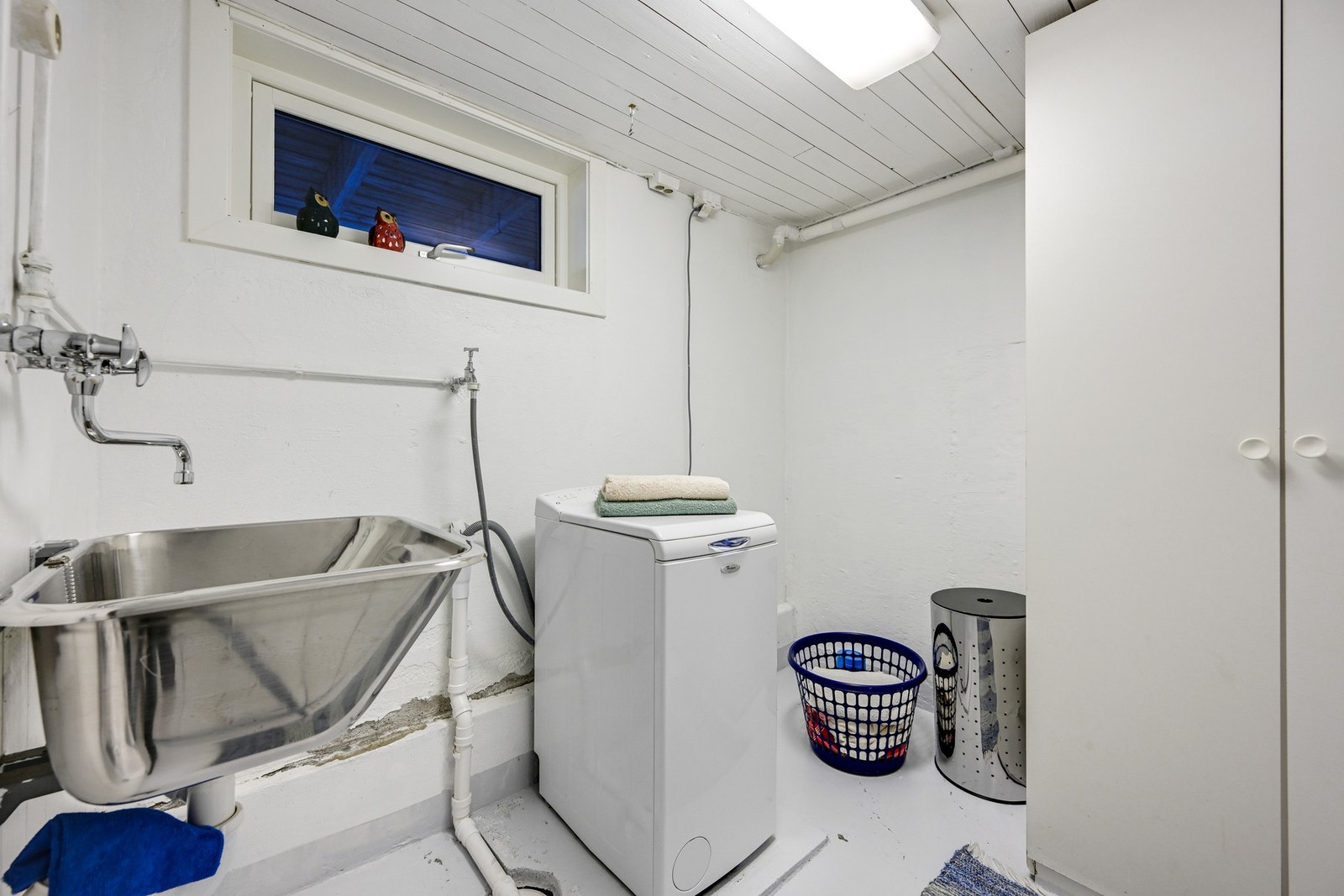 Eget vaskerom i kjelleren med skyllekum og klesskap Galleribilde