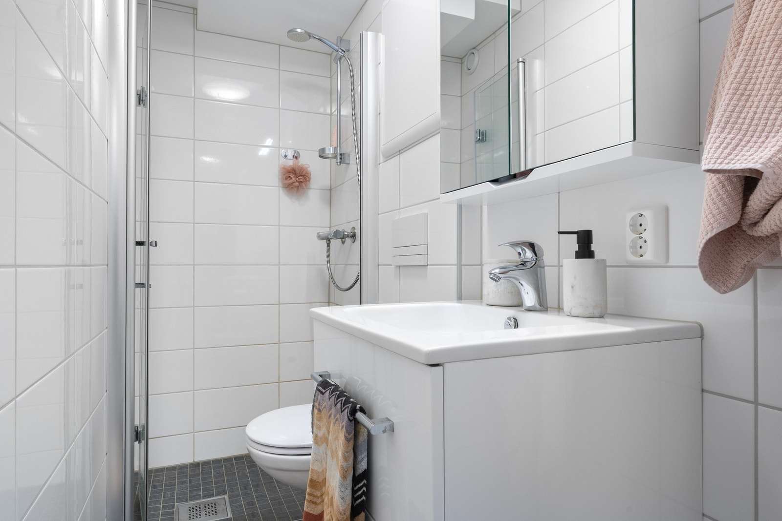 Baderommet er helfliset med mosaikkfliser i nedsenket dusjsone. Galleribilde