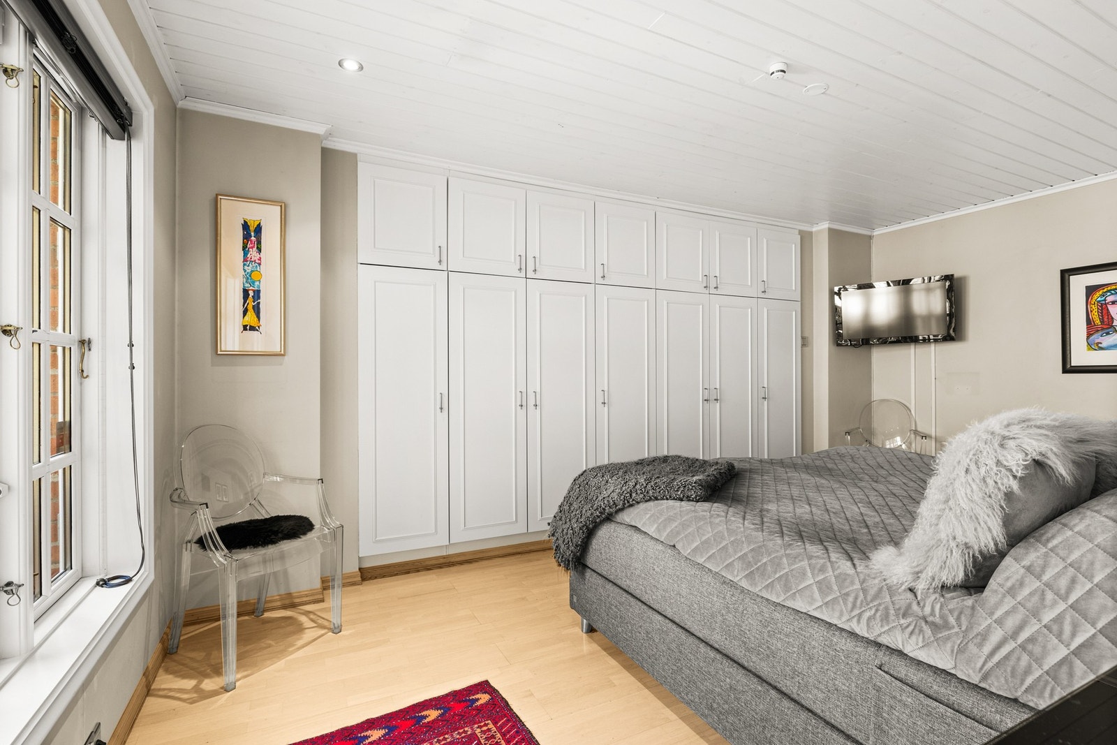 Rommet er innredet med et plassbygget garderobeskap som strekker seg over én hel vegg - noe som gir svært god oppbevaringsplass og et ryddig, integrert uttrykk. Galleribilde