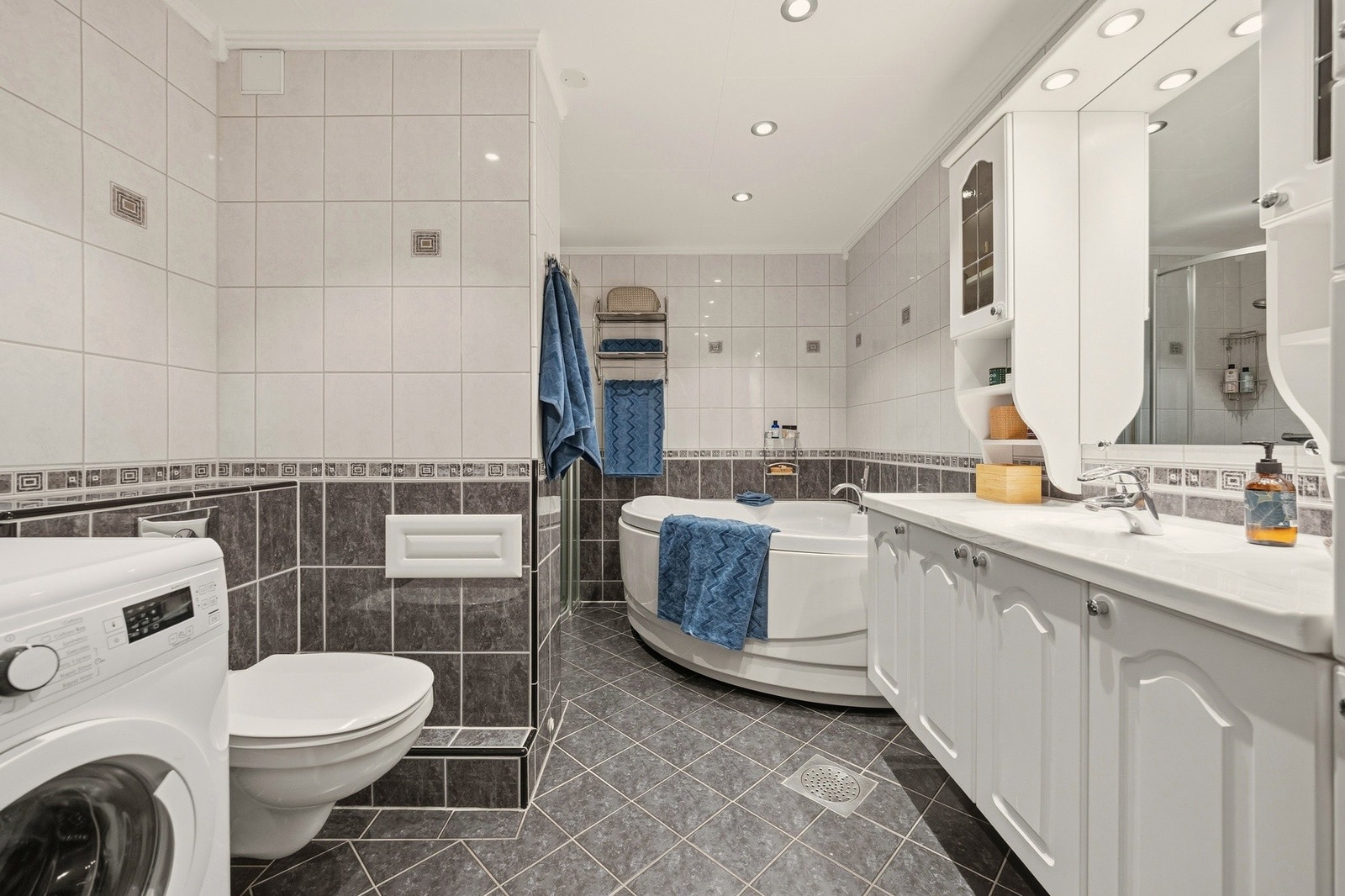 Stort flislagt bad med opplegg til vaskemaskin Galleribilde