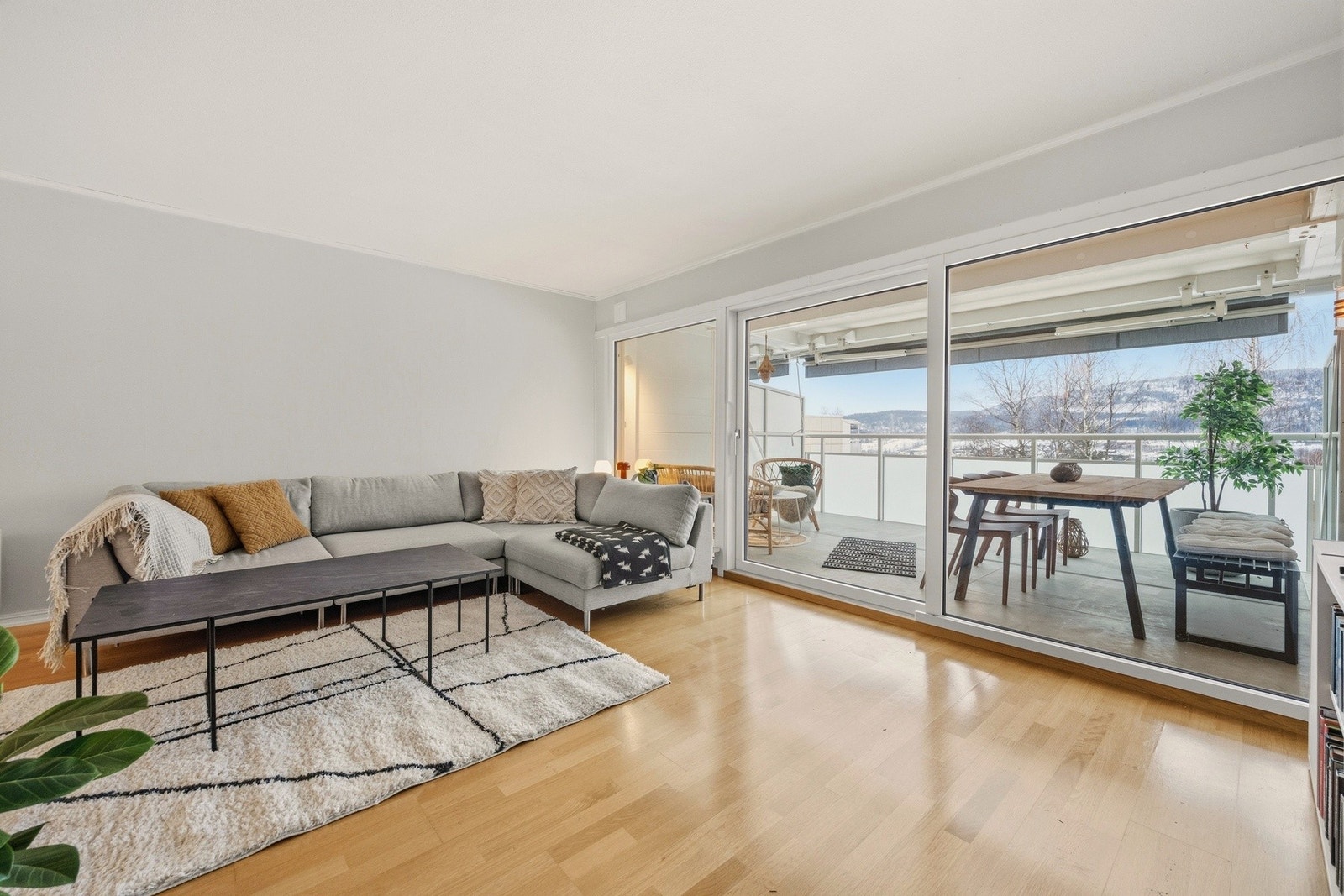 Stuens store vindusflater gir rikelig med naturlig lysinnslipp inn i leilighetens sosiale sone Galleribilde