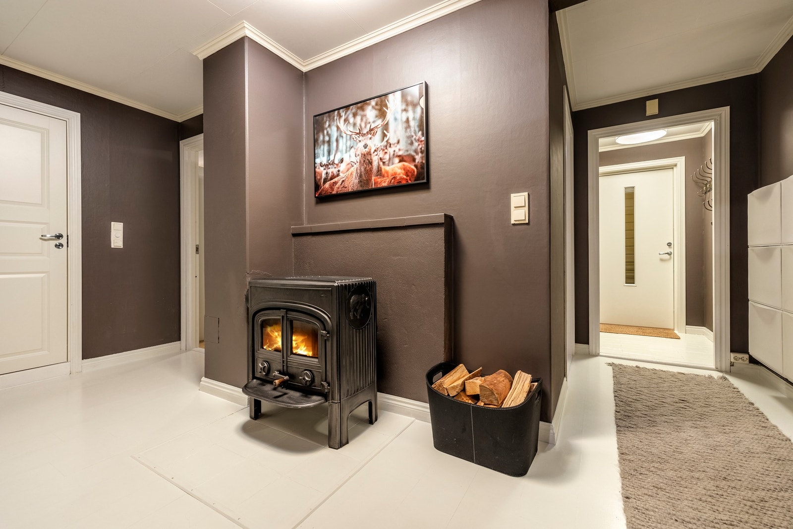 Videre inn i boligen kommer du inn til gangen som er utstyrt med en vedovn. Galleribilde