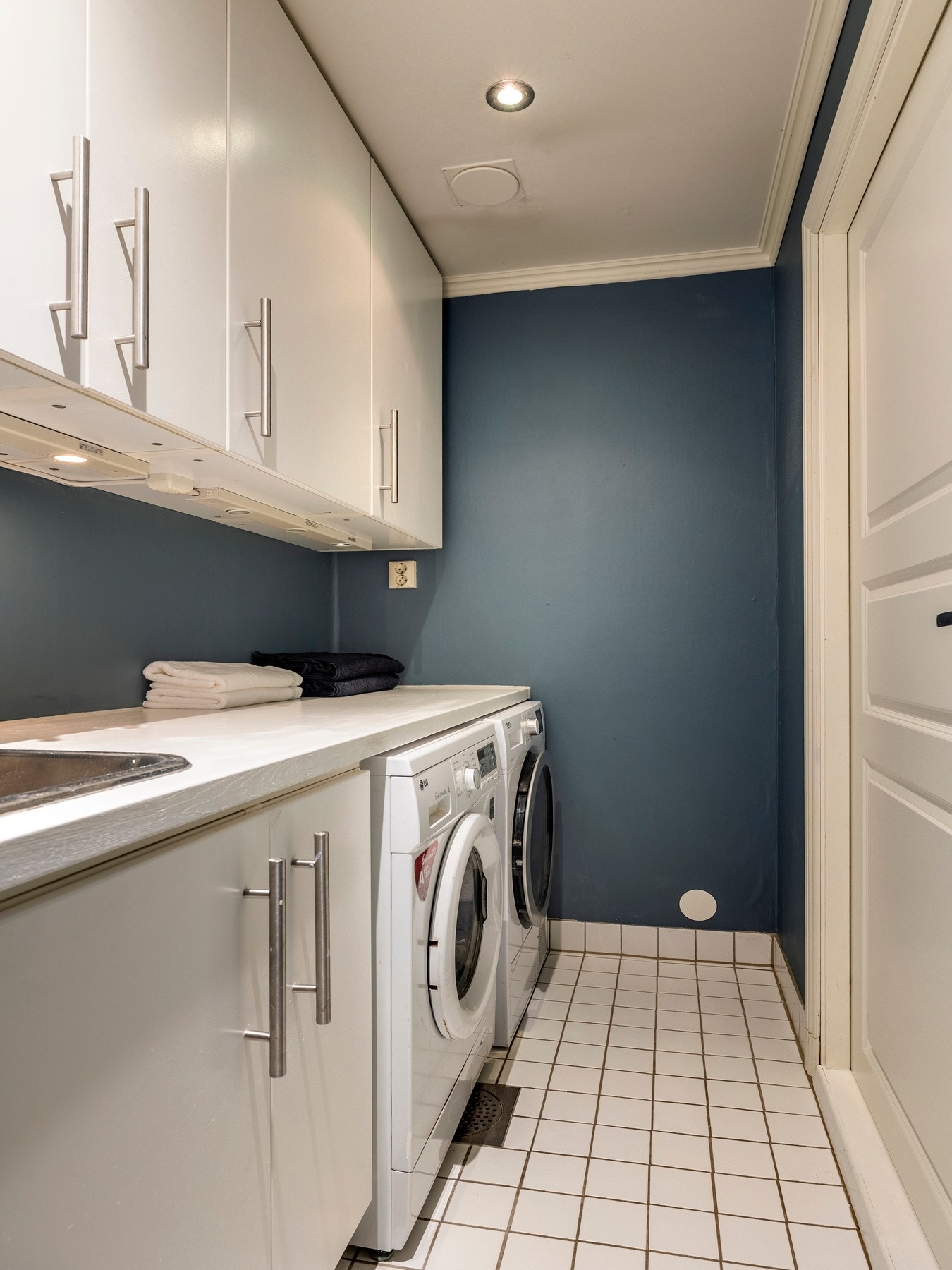 Vaskerommet har innredning med flere skap og laminert benkeplate med nedfelt skyllekum. Det er opplegg for vaskemaskin og plass for tørketrommel under benkeplaten. Galleribilde