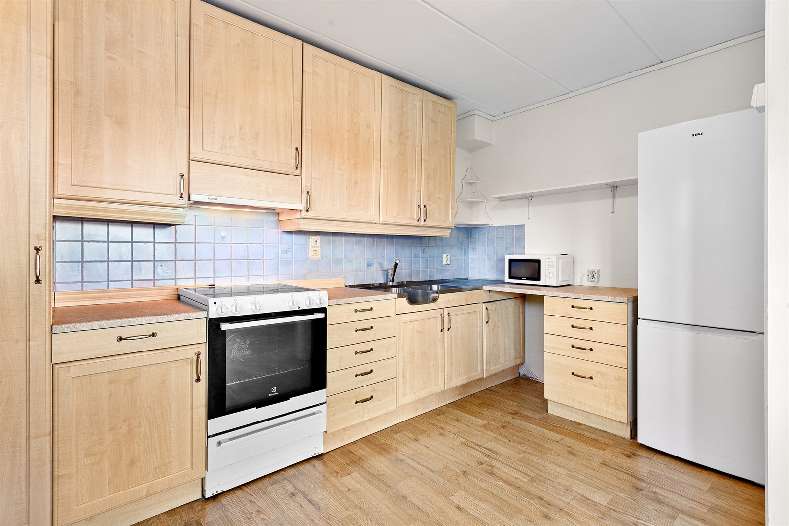 Flislagte felt på vegg over benkeplater av laminat Galleribilde