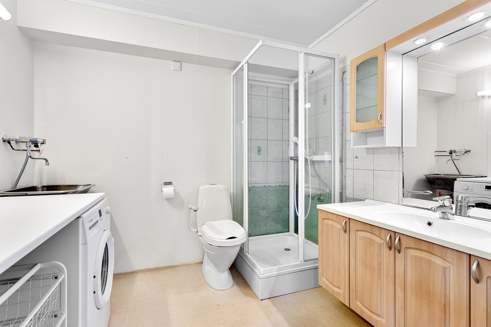 Badet har dusjkabinett, vegghengt utslagsvask og gulvvarme Galleribilde