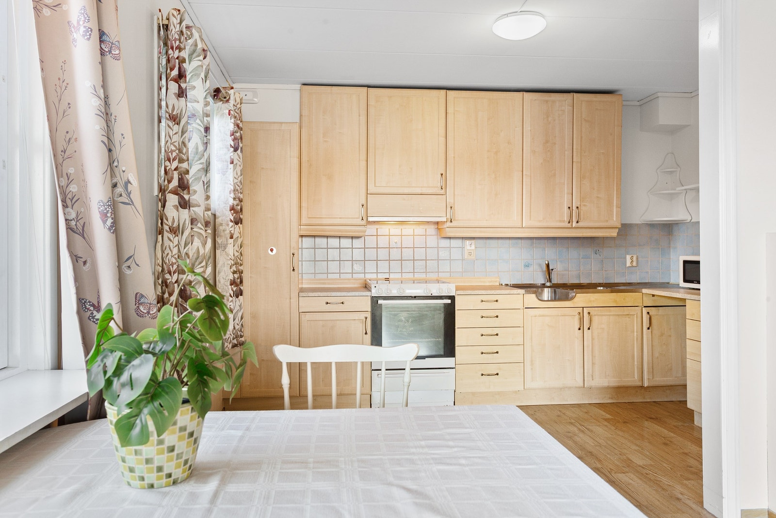 Profilert kjøkkeninnredning med over- og underskap samt høyskap Galleribilde