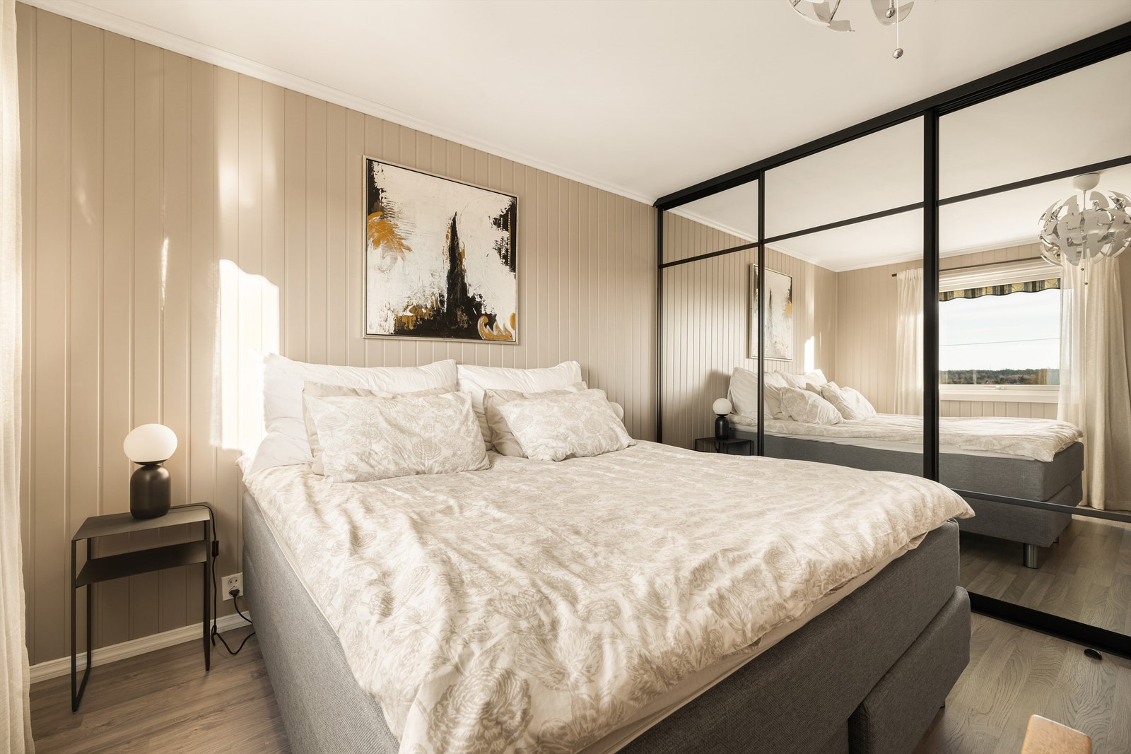 Bred skyvedørsgarderobe oppbevarer klærne lett tilgjengelig ved sengens side. Galleribilde