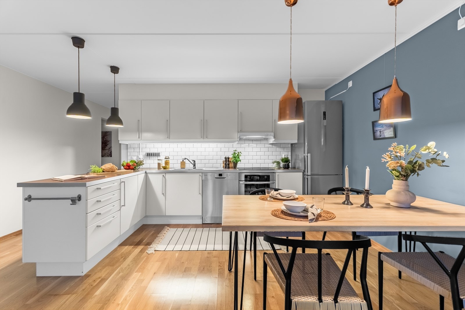 Kjøkkenet er tidløst med glatte, fabrikklakkerte fronter og laminat benkeplate med nedfelt kum i rustfritt stål. Galleribilde