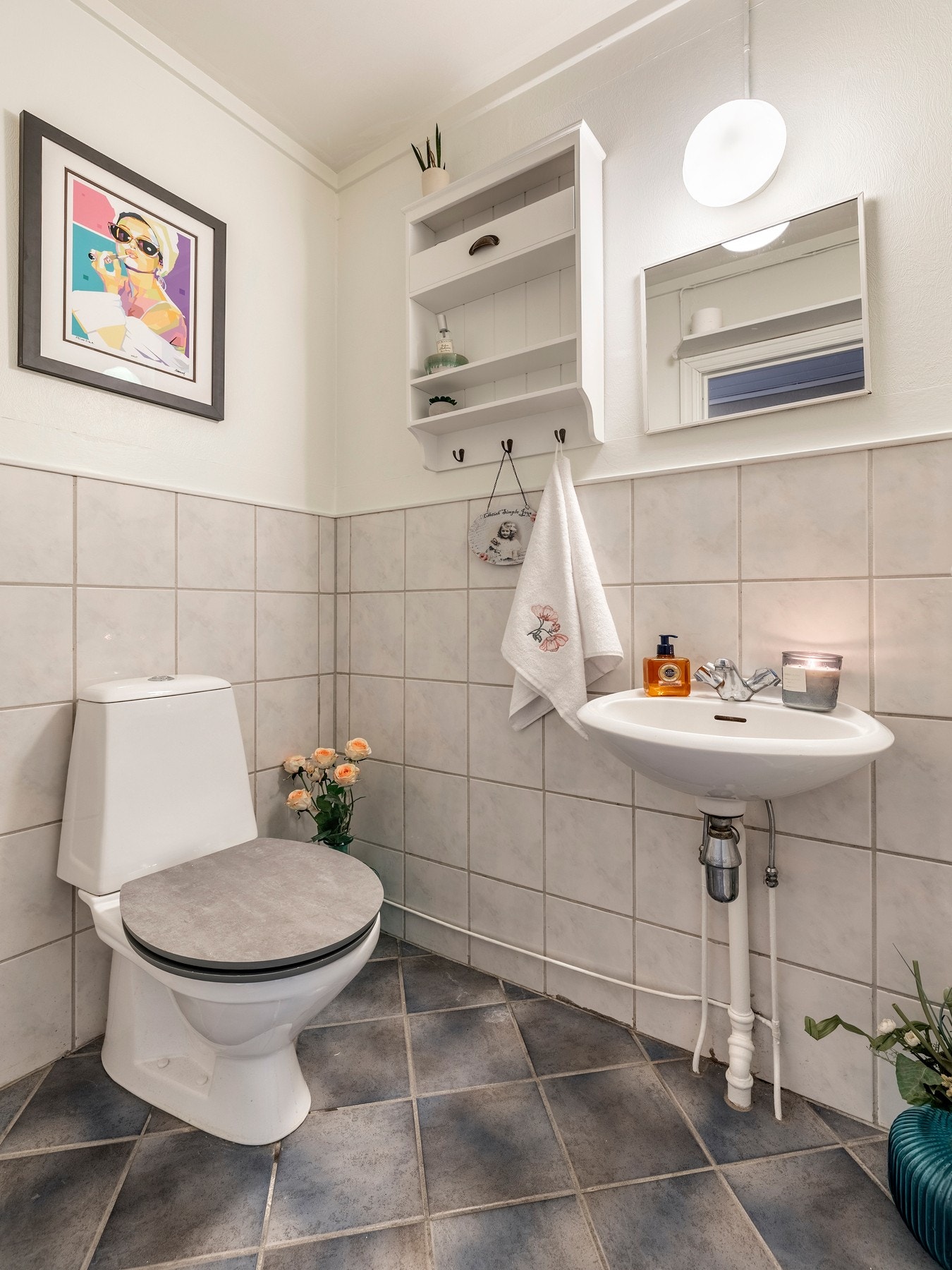 Toalettrommet er innredet med servant, speil og lys på vegg, samt et toalett. Galleribilde