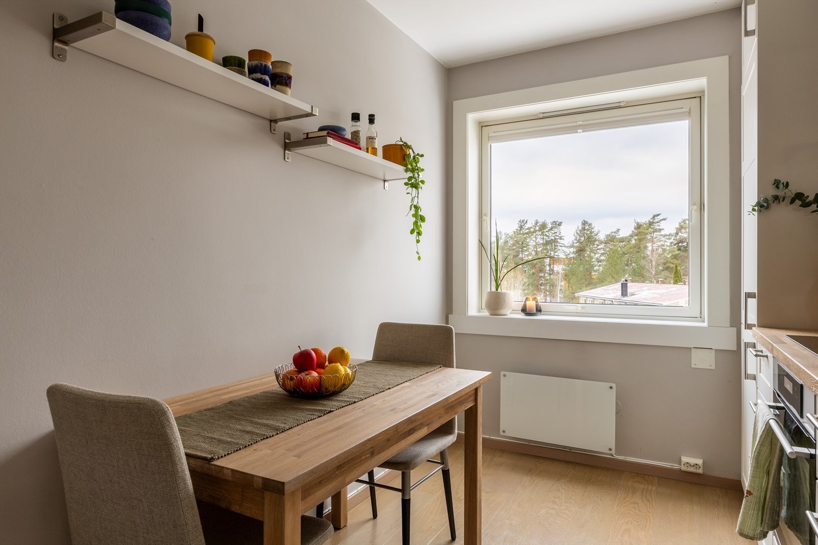 Kjøkkenet har god plass til spisebord og det er montert en moderne panelovn på vegg. Vinduet gir godt naturlig lys. Galleribilde