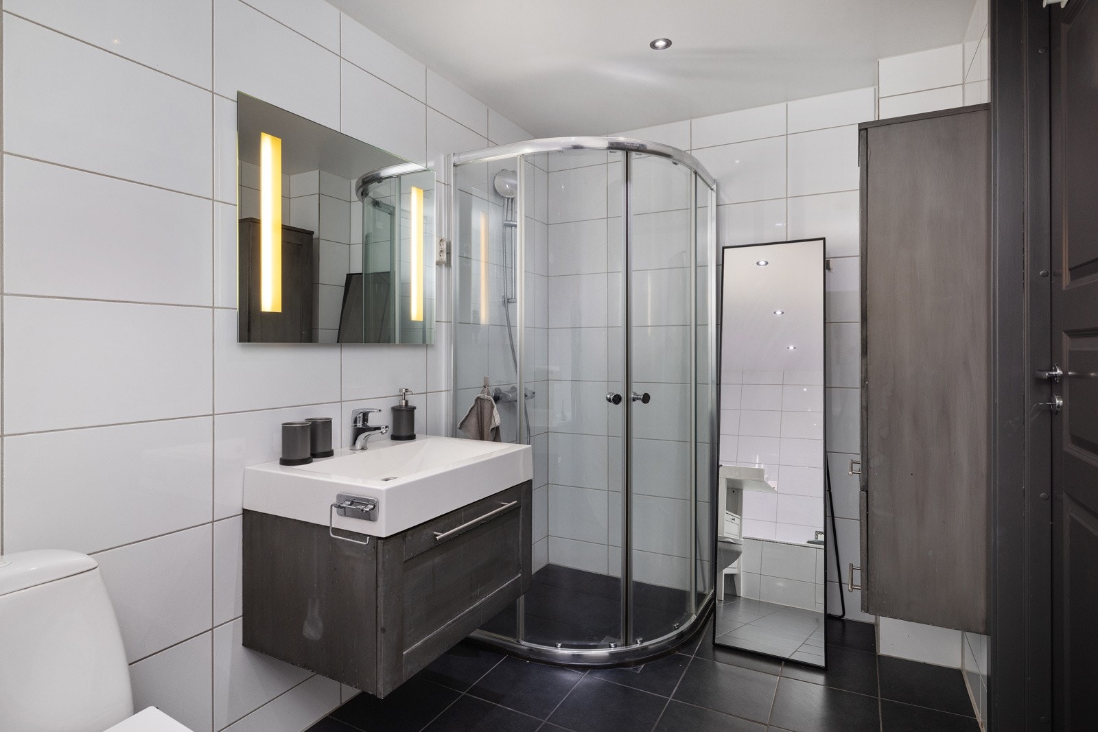 Fra hallen er det adkomst til et romslig bad med både badekar og dusjhjørne. Galleribilde