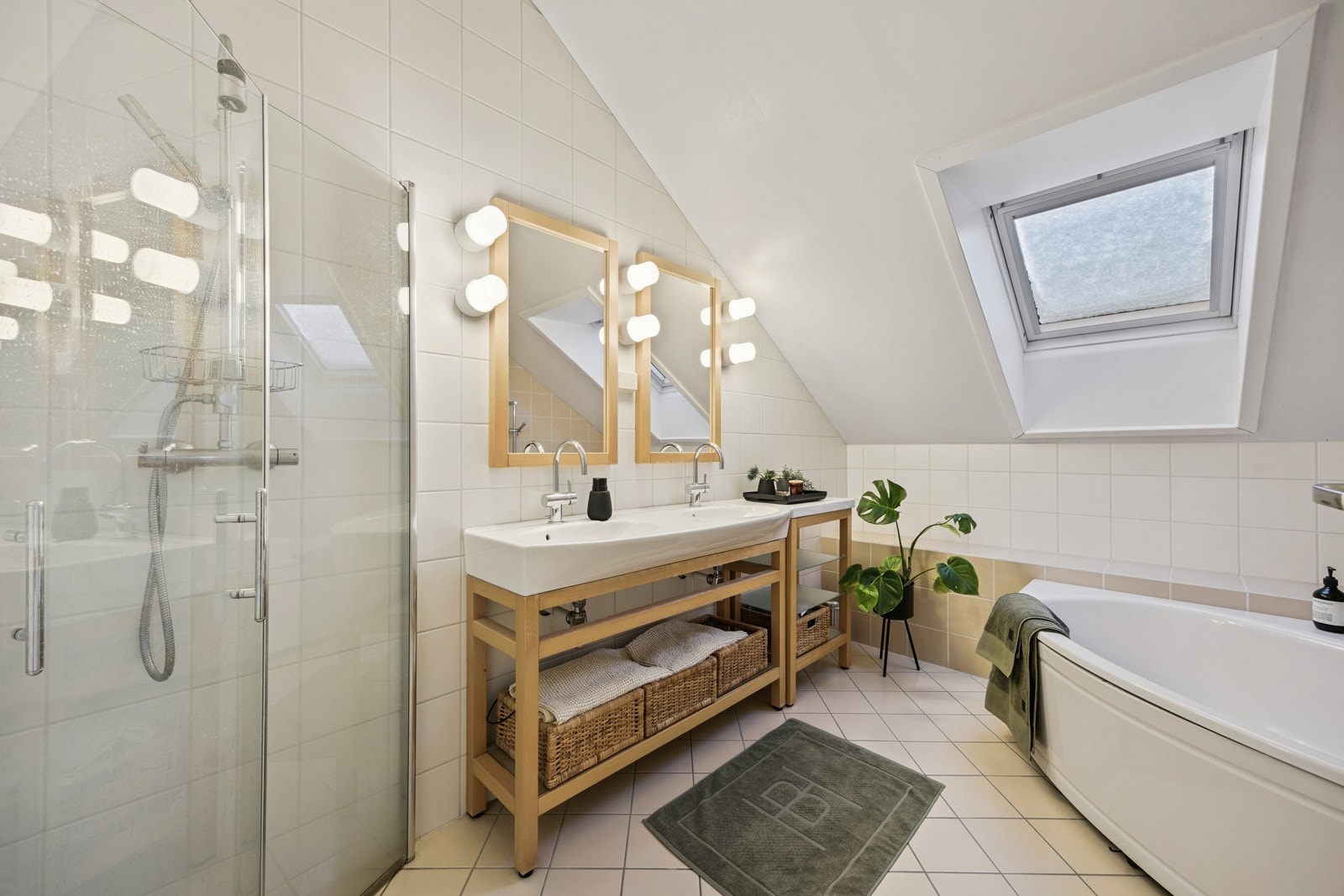 Badet i andre etasje er romslig og flislagt, og inneholder badekar, dusjnisje, dobbel servant og vegghengt toalett. Elektriske varmekabler i gulvet gir god komfort. Galleribilde